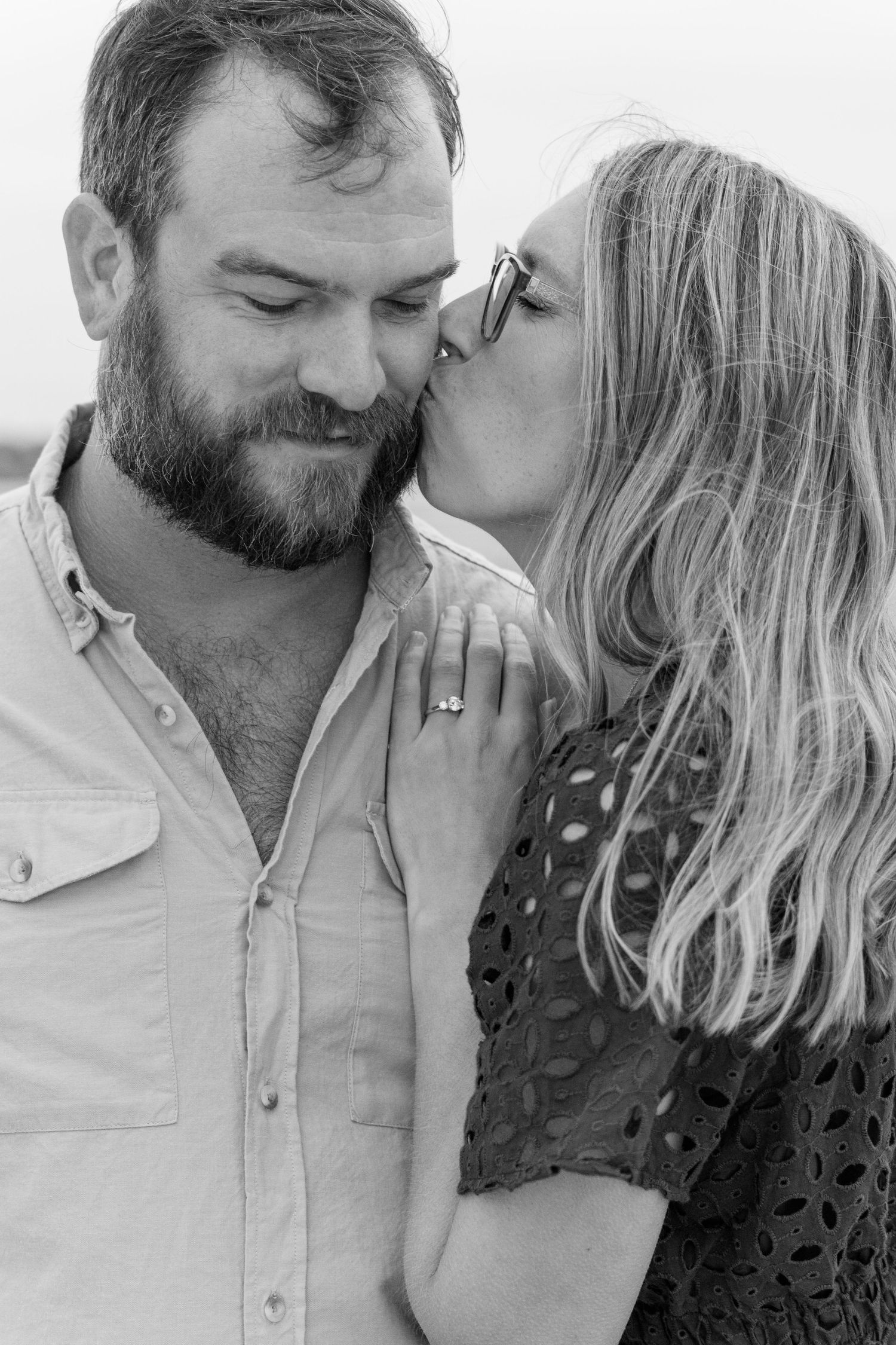 An intimate black and white portrait of a couple sharing a tender moment.