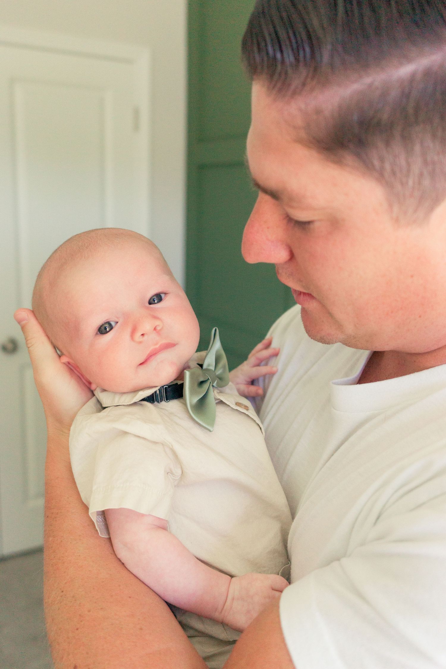 Sweet interaction in front of mint green wall.