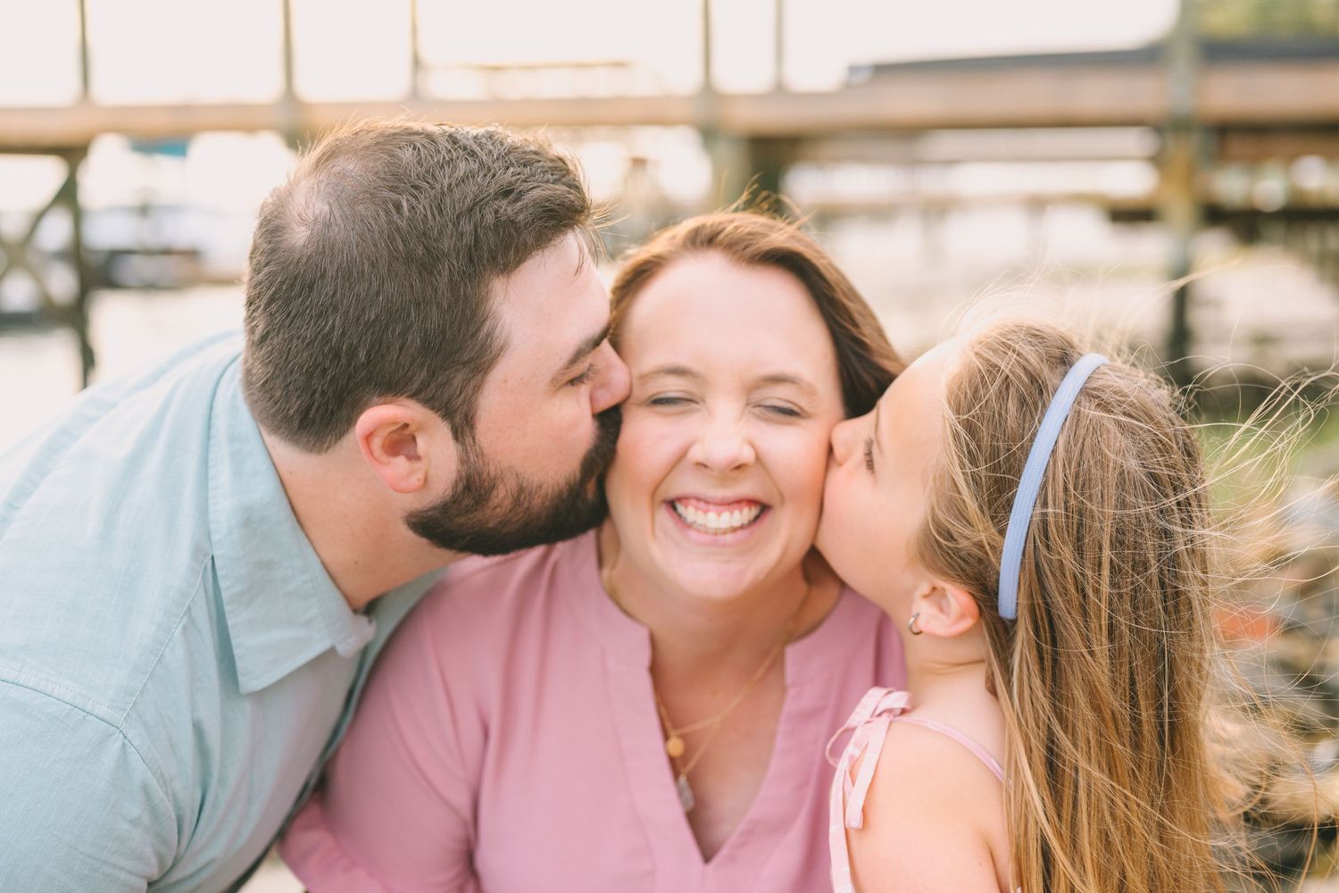 A joyful and heartwarming scene at a marina shows a family sharing a tender moment of affection together.