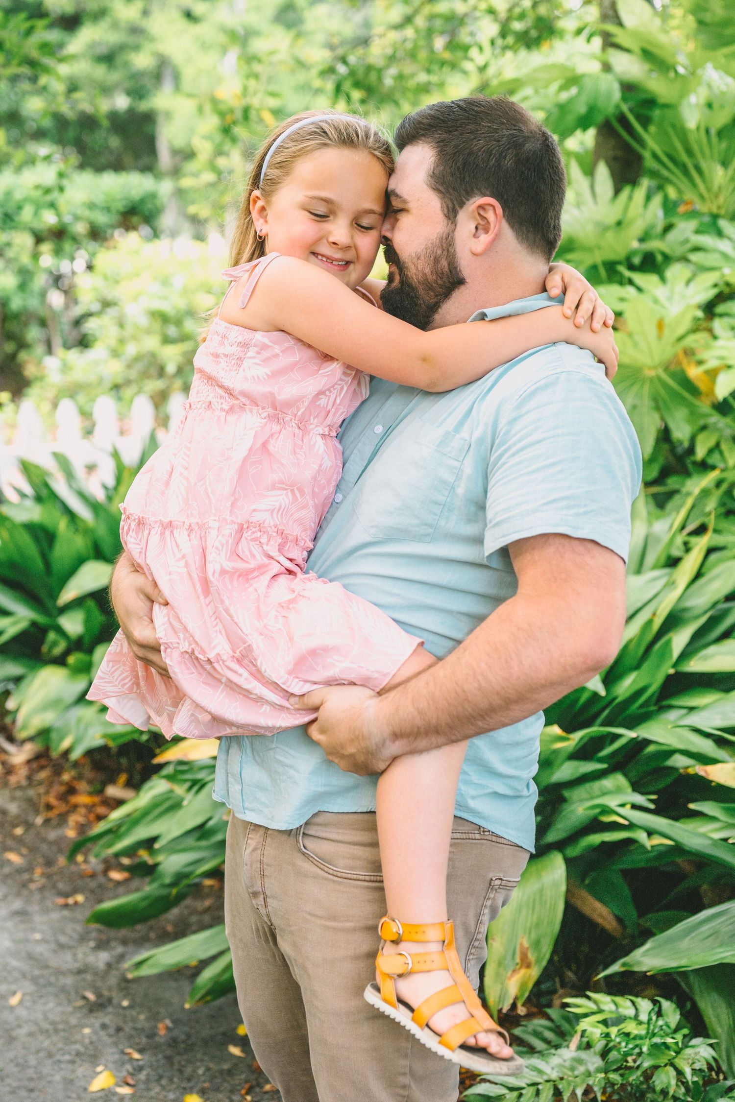 A tender embrace between two people sharing a joyful moment in a lush garden setting on a sunny day.