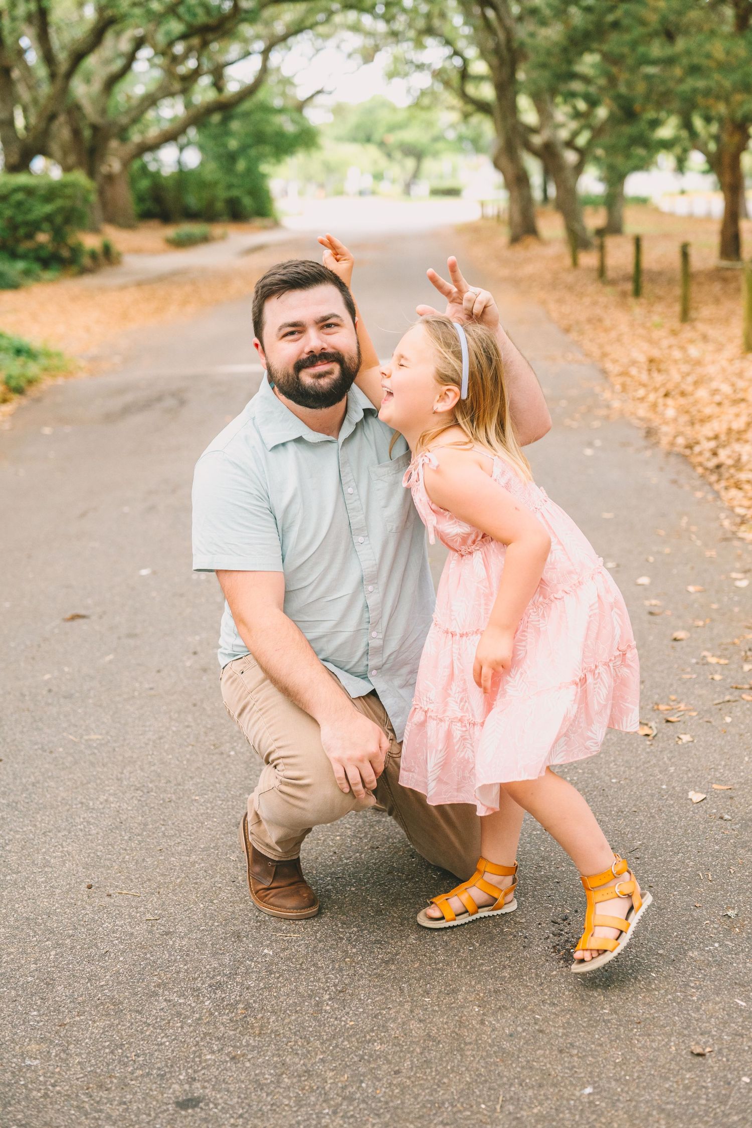 A heartwarming candid moment between two people sharing laughter on a tree-lined path.