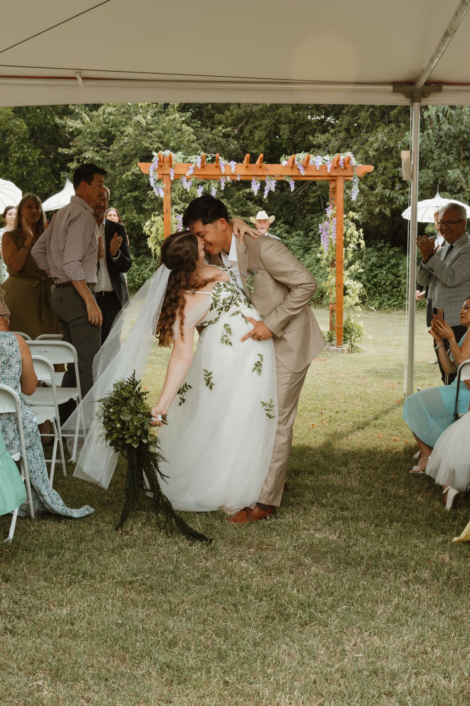 Wedding party celebrating under a tent with orange and white decorative elements.