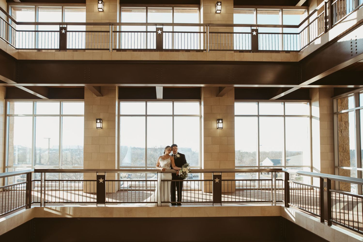 Modern industrial office interior with floor-to-ceiling windows, wooden floors and metal railings in an open concept space.