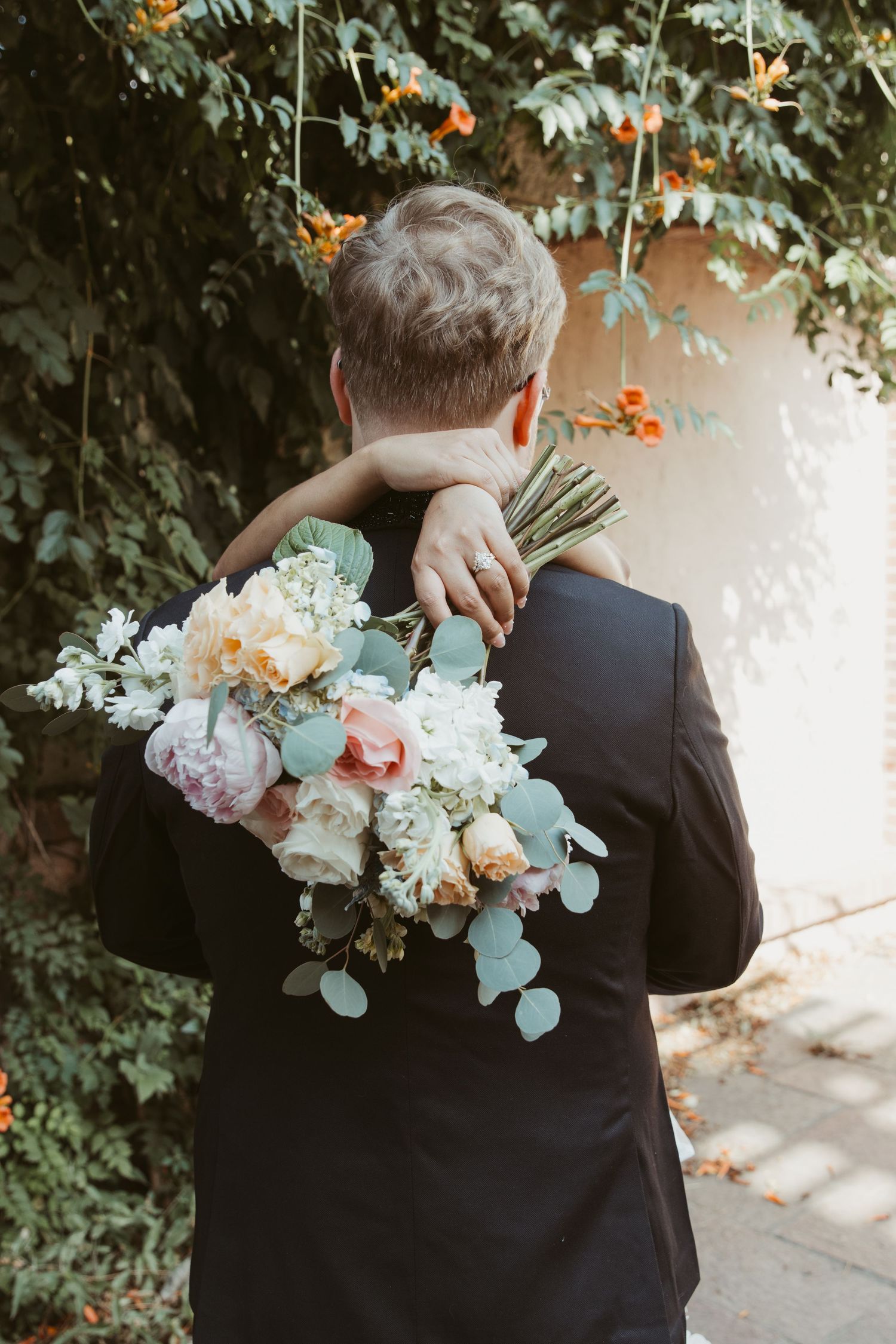 Elegant floral bouquet with white and peach blooms creates a romantic atmosphere in an outdoor garden setting.