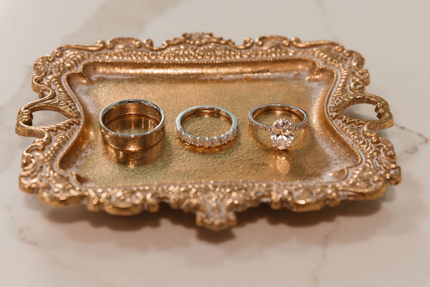 Ornate gold-plated drawer pulls and cabinet handles with intricate baroque-style designs displayed in a row. Wedding Photographer DFW