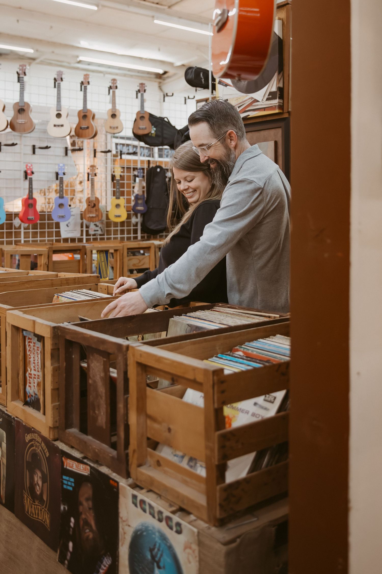 People browsing through wooden display cases filled with collectibles and merchandise in a vintage shop.