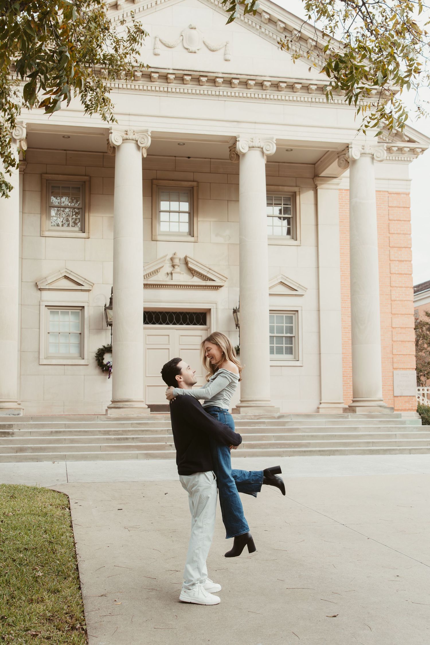 Couple dancing and embracing in front of a grand historic building with classical columns engagement photos Fort Worth