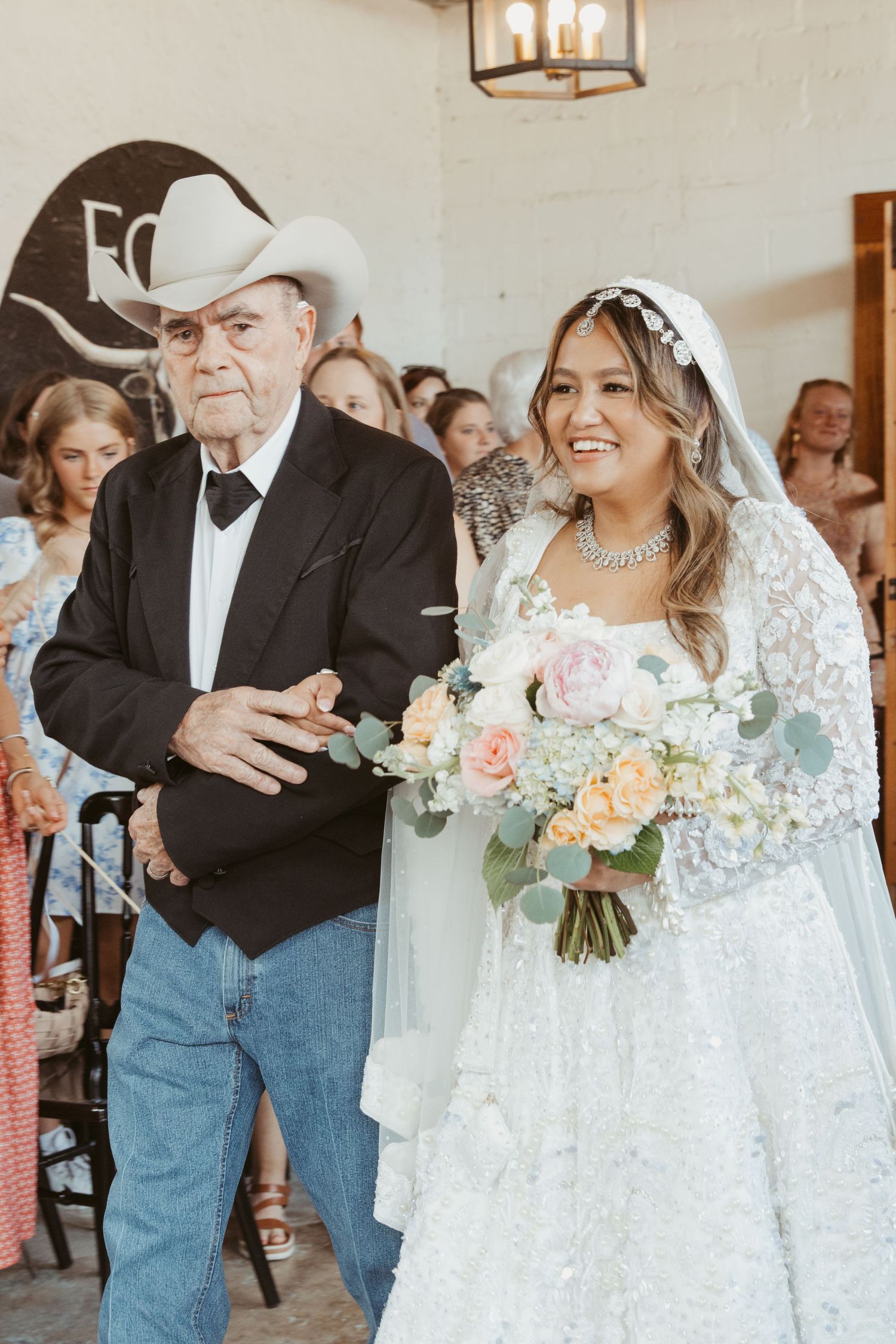 A traditional wedding processional featuring a lace-clad bride with her escort walking down the aisle.