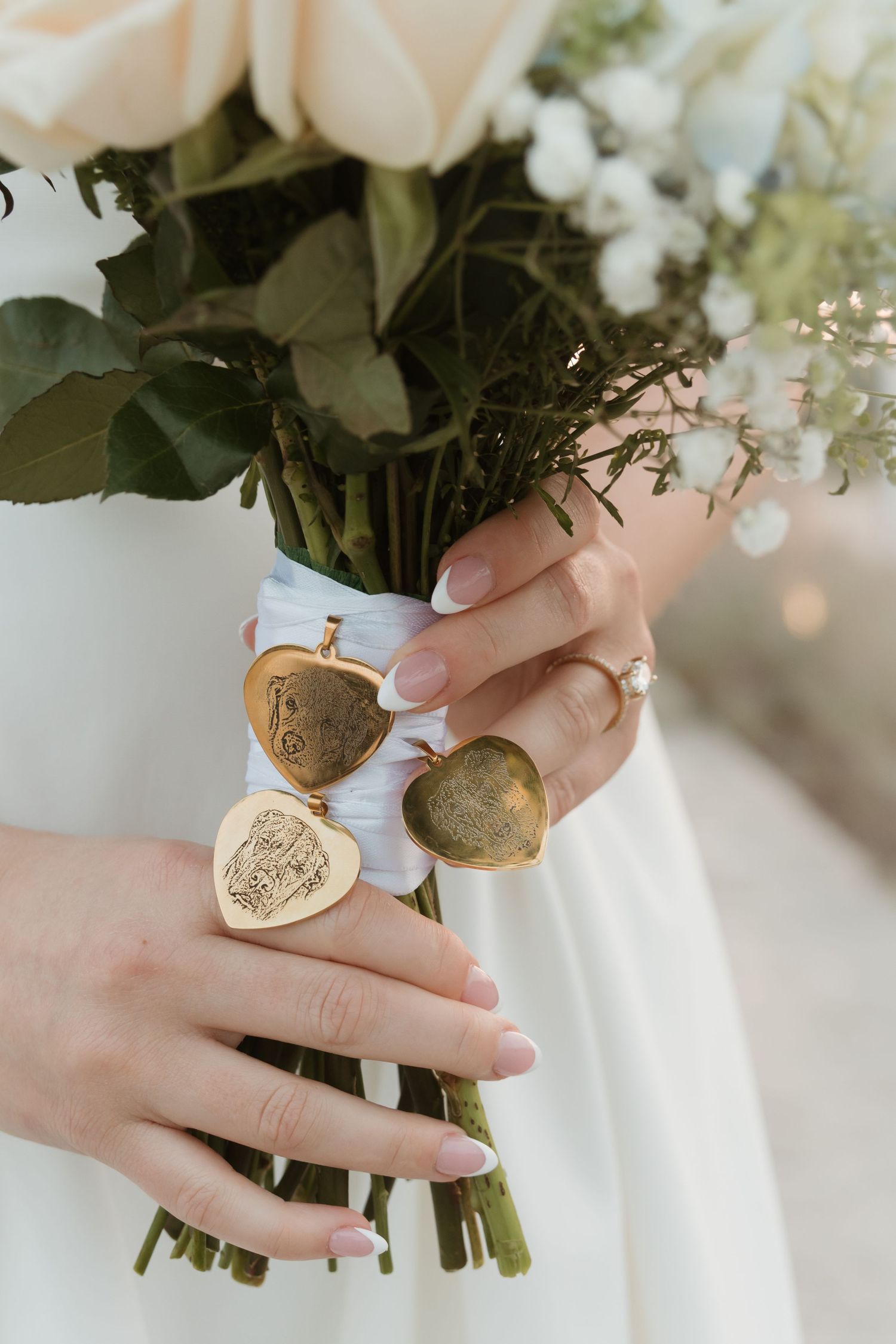 A close-up series of hands holding a wedding bouquet with vintage brass charms and white flowers.