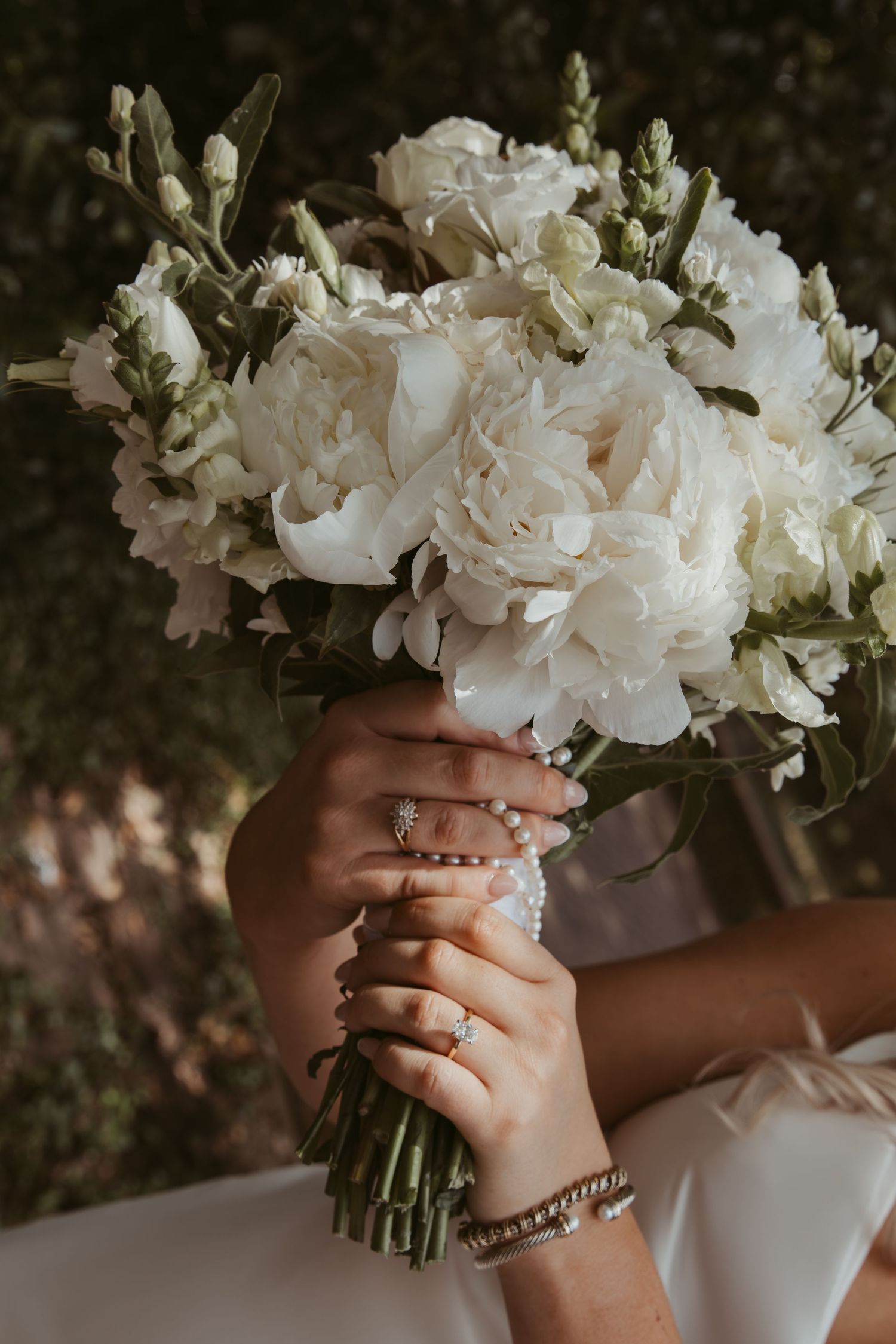 Close-up shots of hands holding a stunning white flower bouquet arranged in a dreamy sequence.