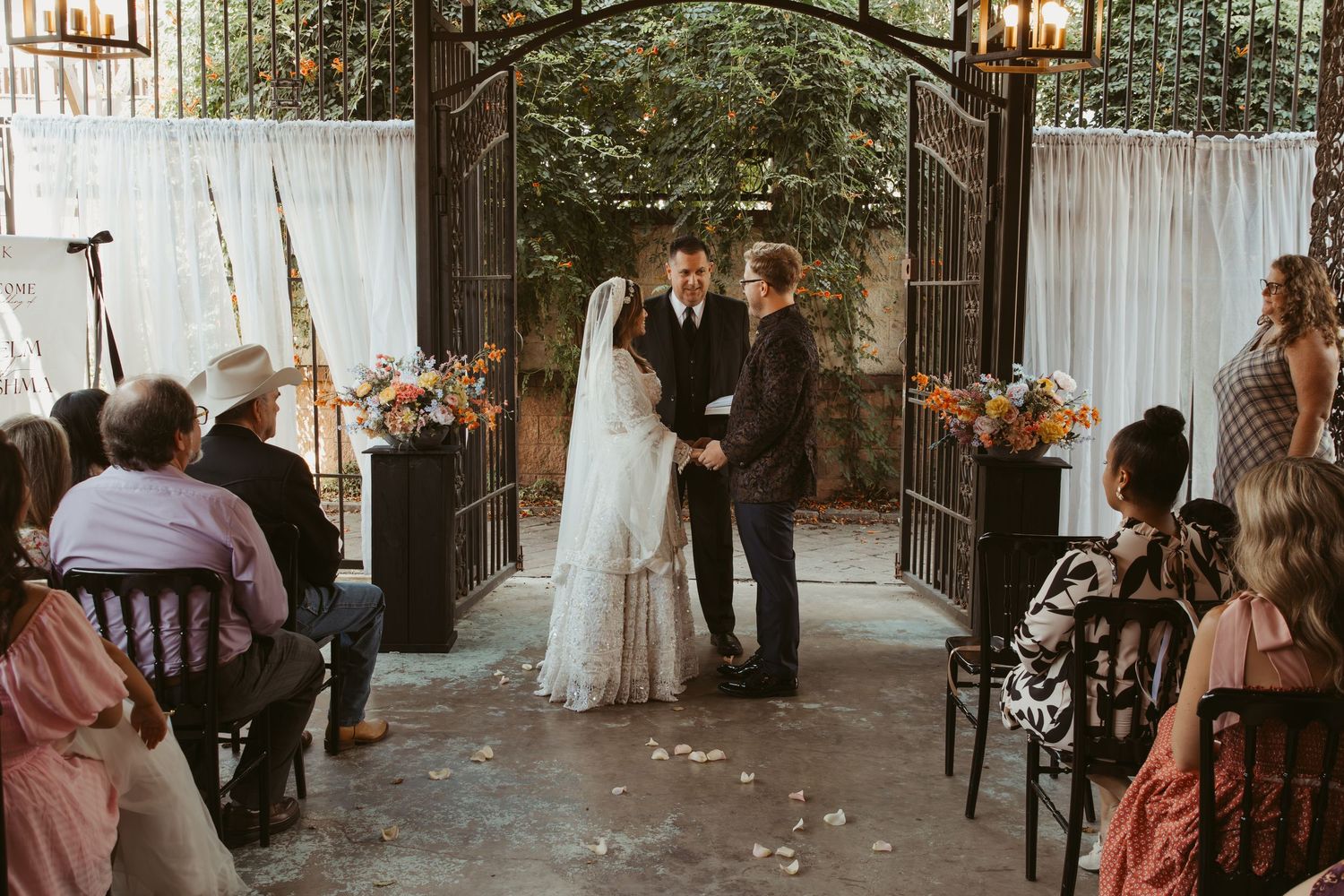 Wedding reception guests celebrate at a beautifully decorated outdoor venue with string lights and rustic decor.