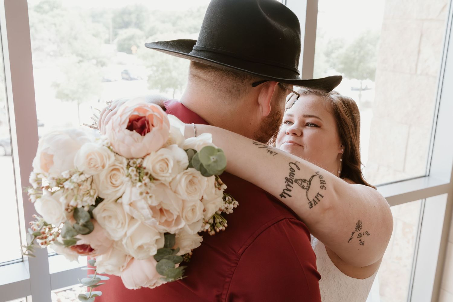 A tender embrace with beautiful floral bouquet during wedding photos.
