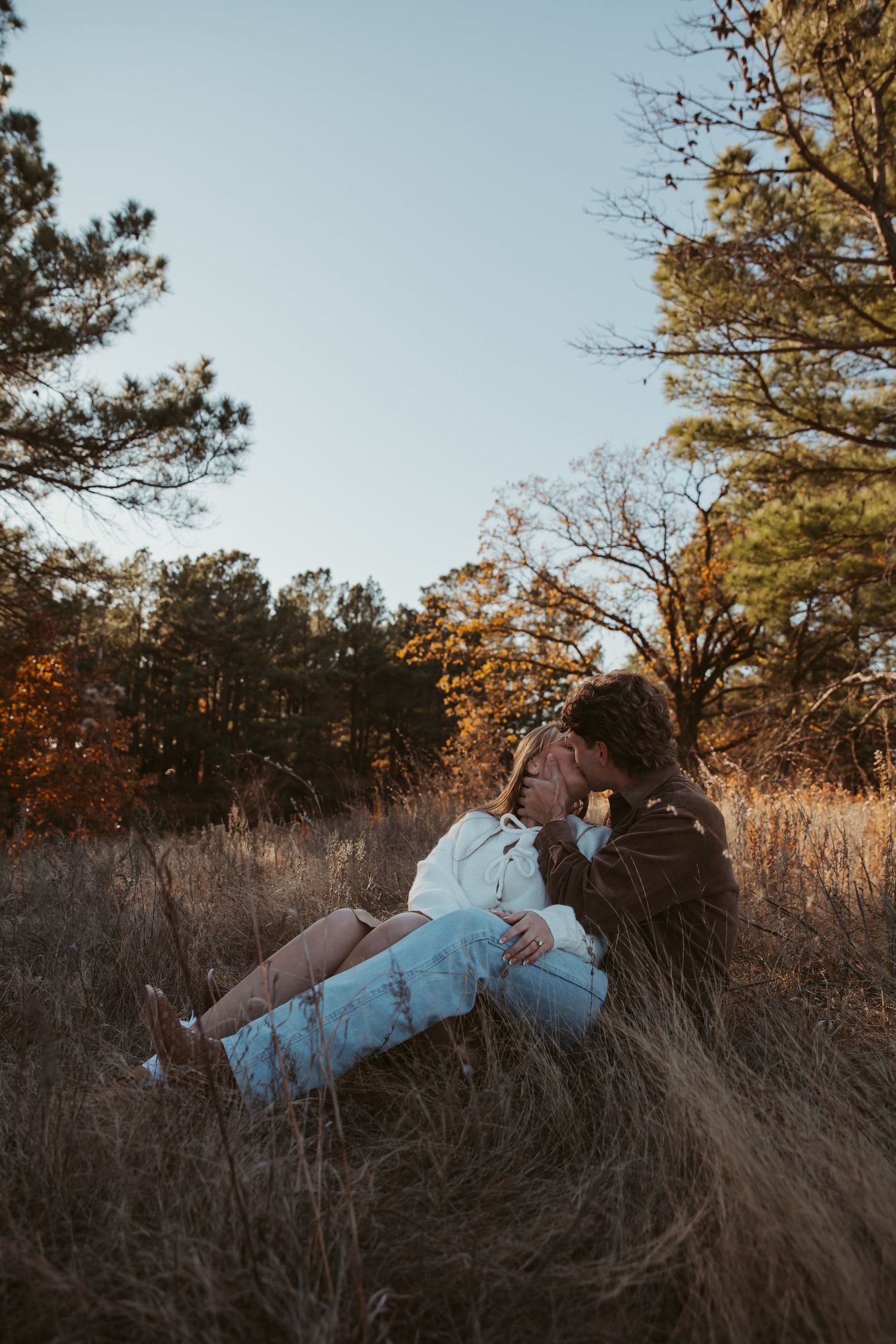 Couple embracing in tall autumn grass during a golden hour photoshoot. engagement photos DFW