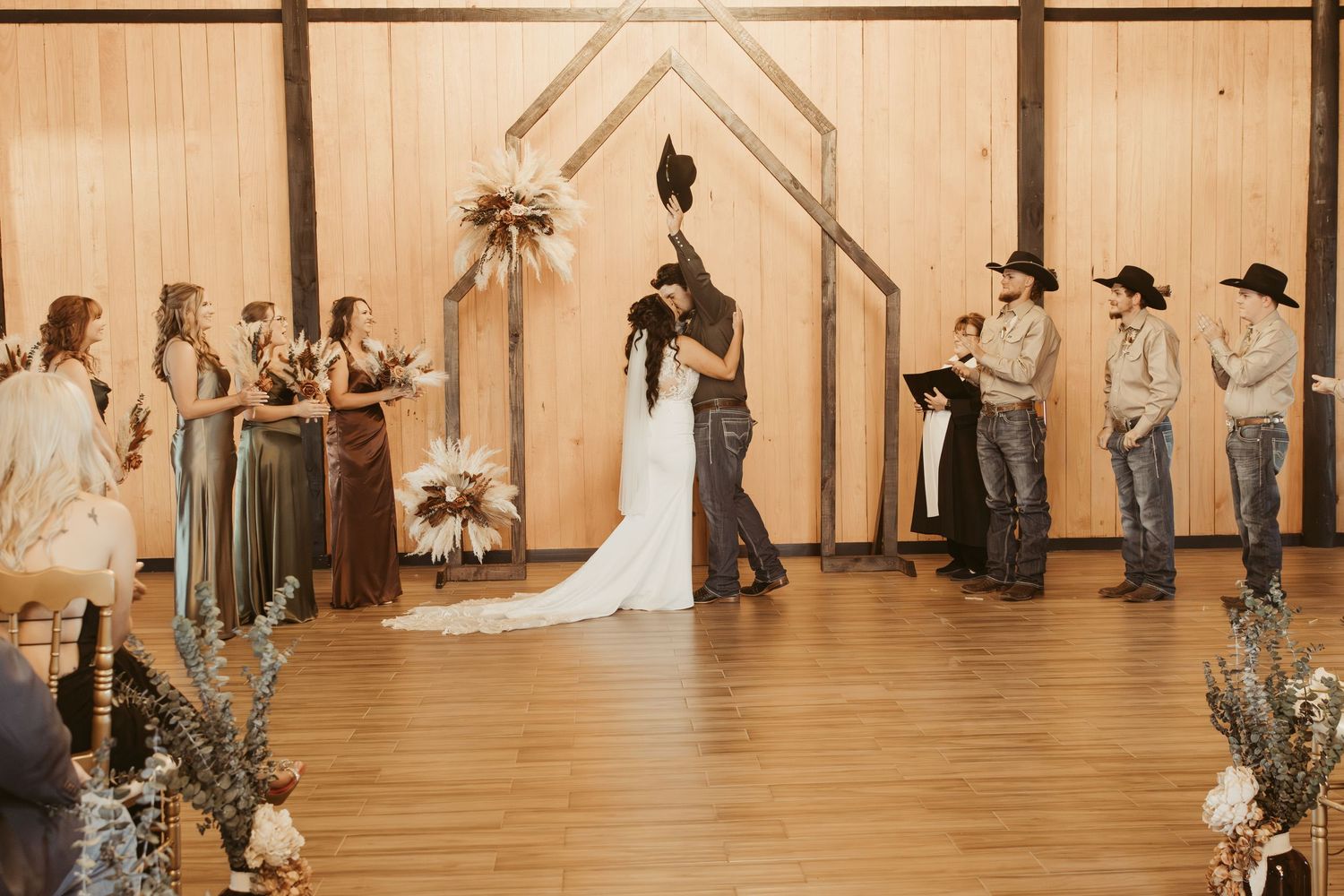 A panoramic view of a rustic barn wedding venue with wooden walls and decorative lighting. Wedding photographer DFW