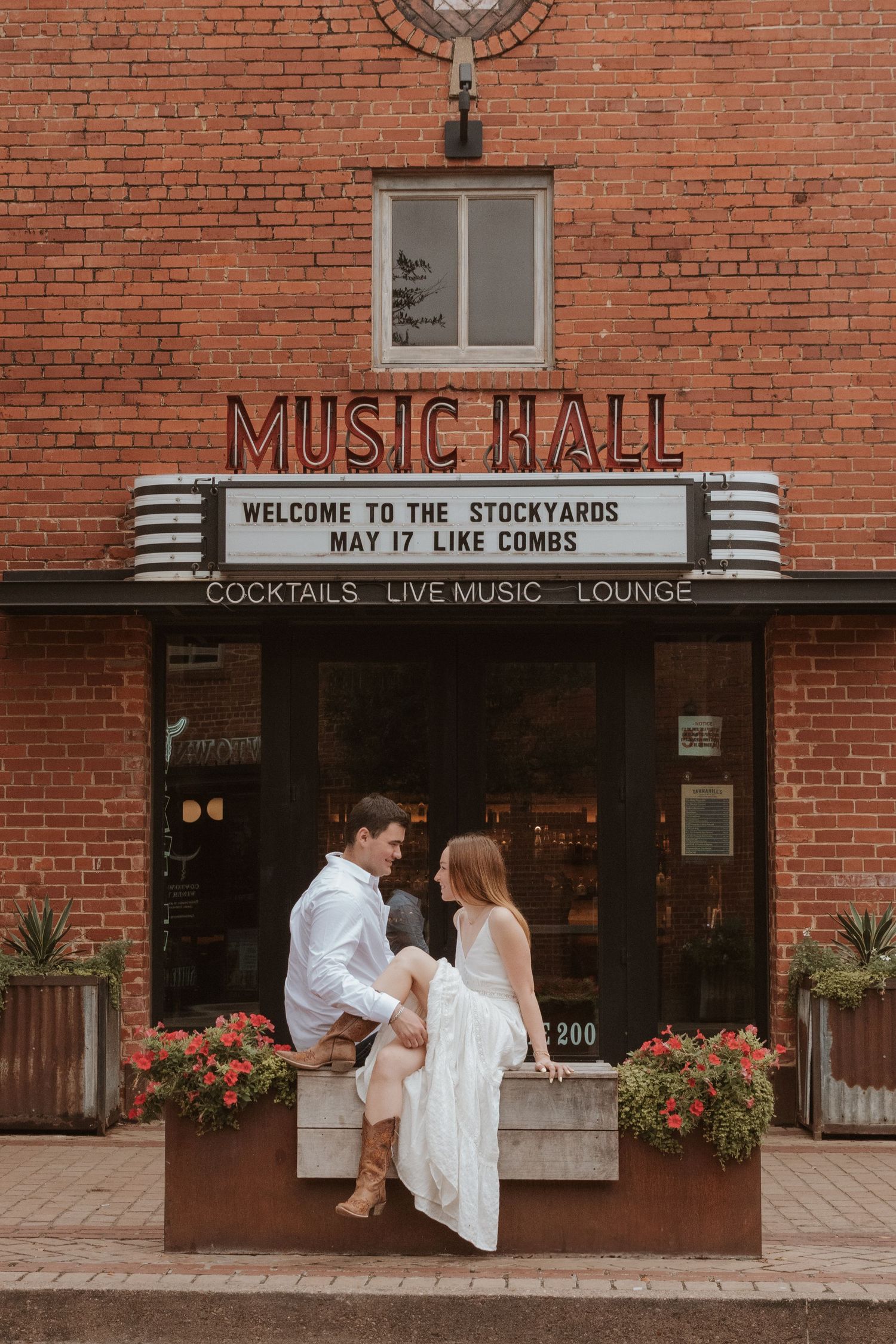 A rustic brick building entrance with 'Music Hall' and 'Welcome to the Stockyards' signage in Fort Worth.