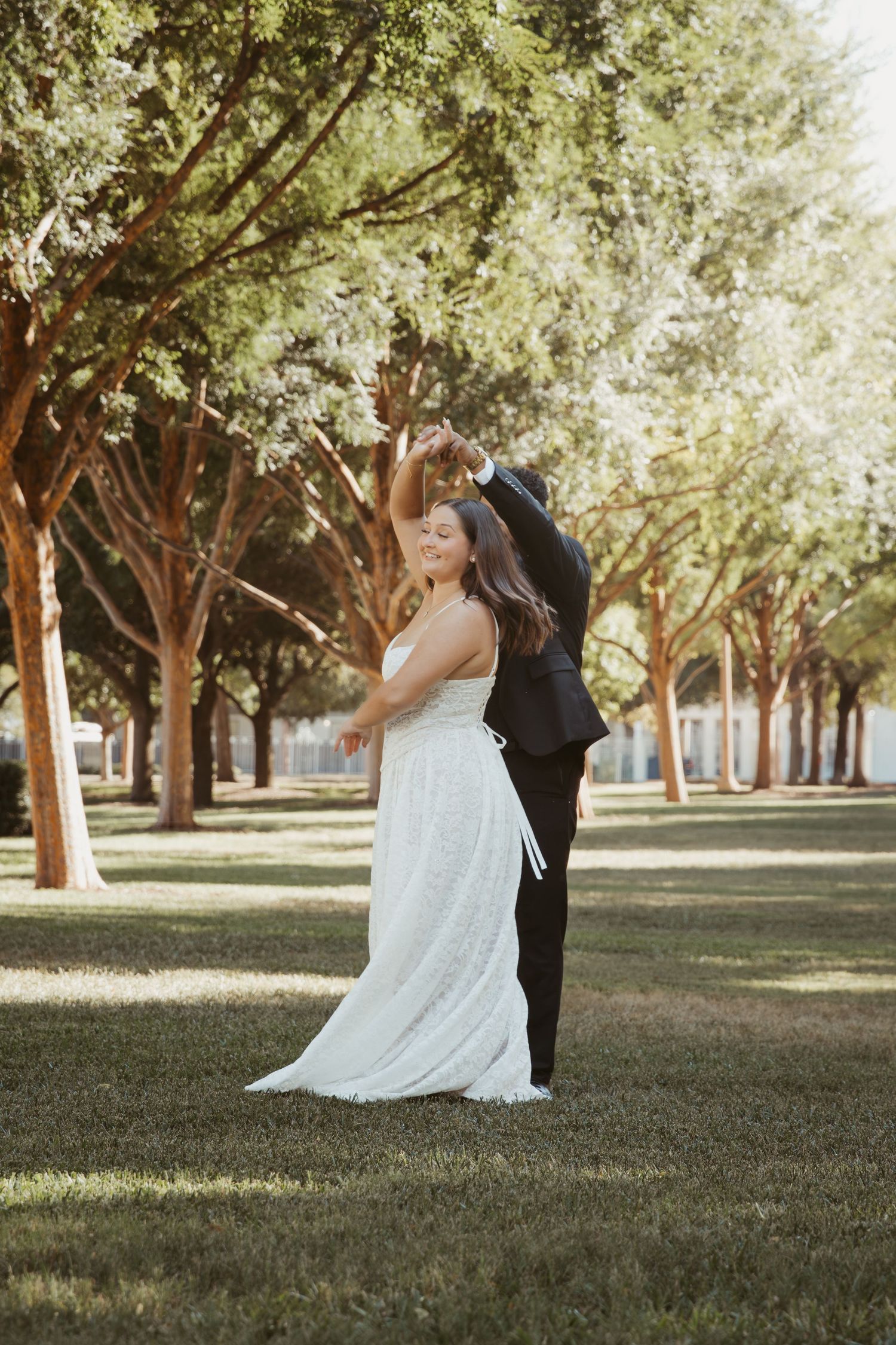 A romantic moment captured between a couple in a sunlit grove of trees. Wedding Photographer DFW