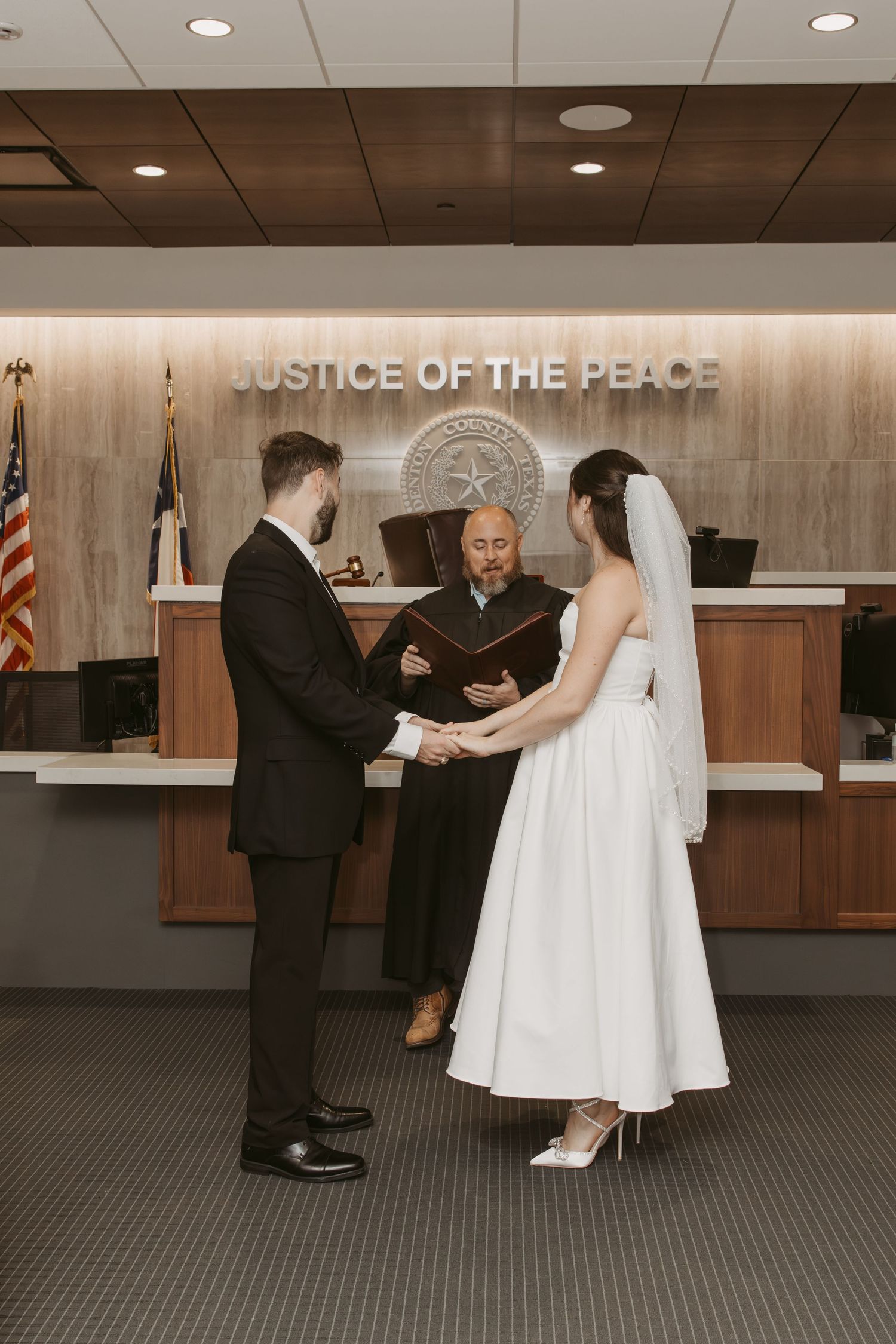 A wedding ceremony taking place at a Justice of the Peace office with a bride in white dress. Wedding Photographer Fort Worth