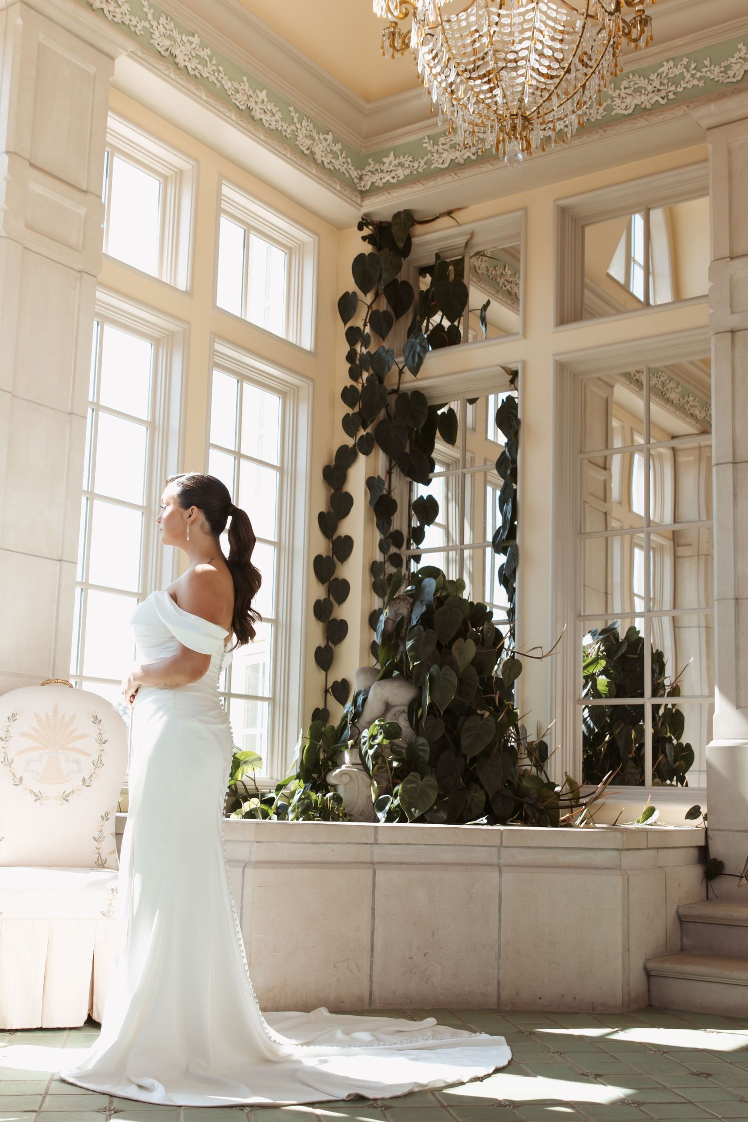 Grand ballroom with crystal chandeliers and ornate details creates a luxurious wedding venue setting.