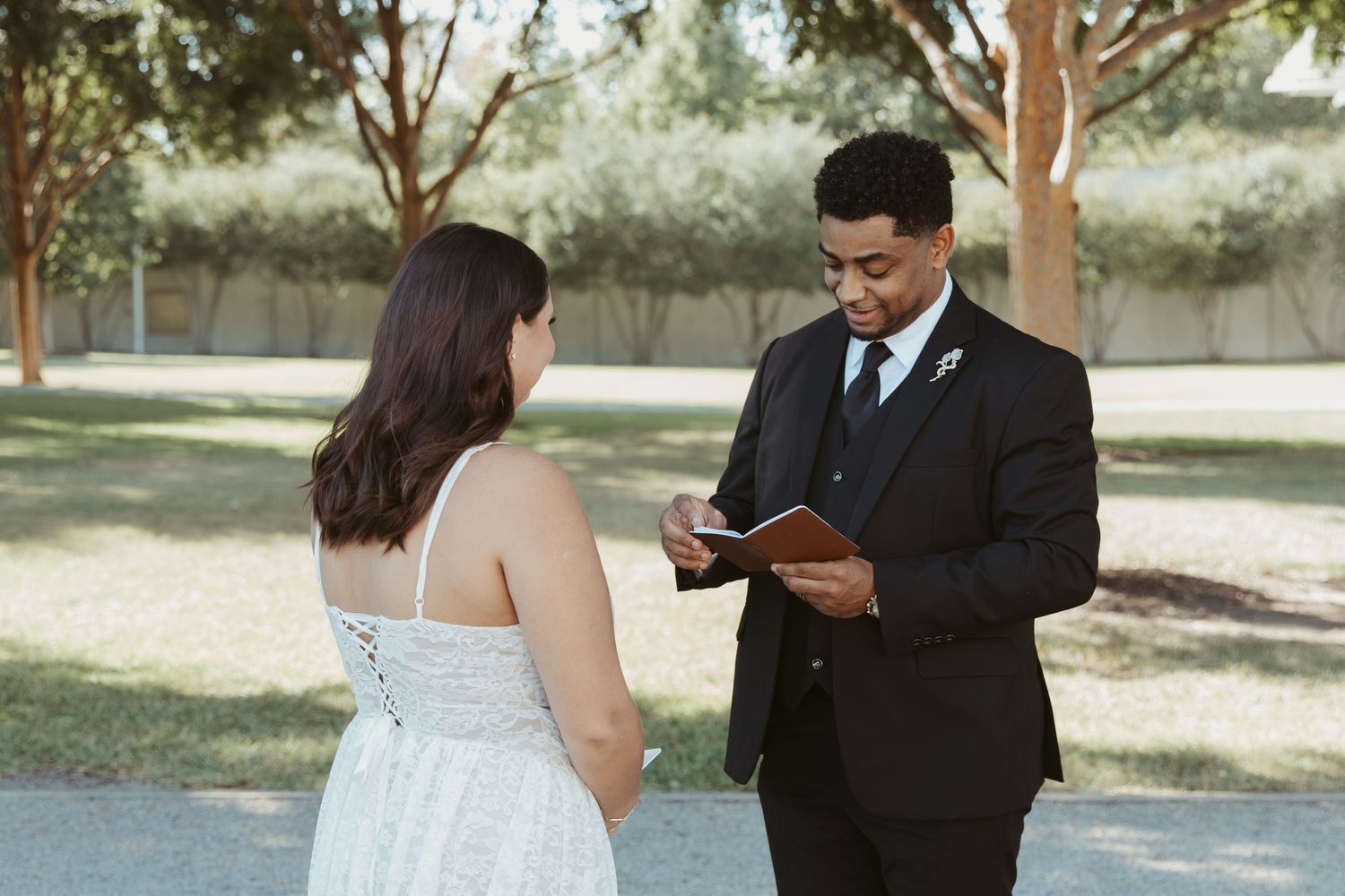 A couple exchanging vows in an outdoor garden setting. Wedding Photographer DFW