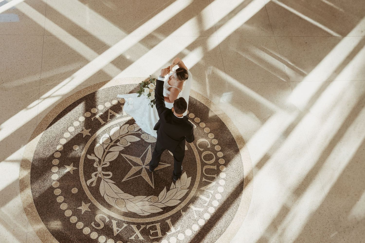 A couple in formal attire performs an elegant dance move during their wedding celebration.