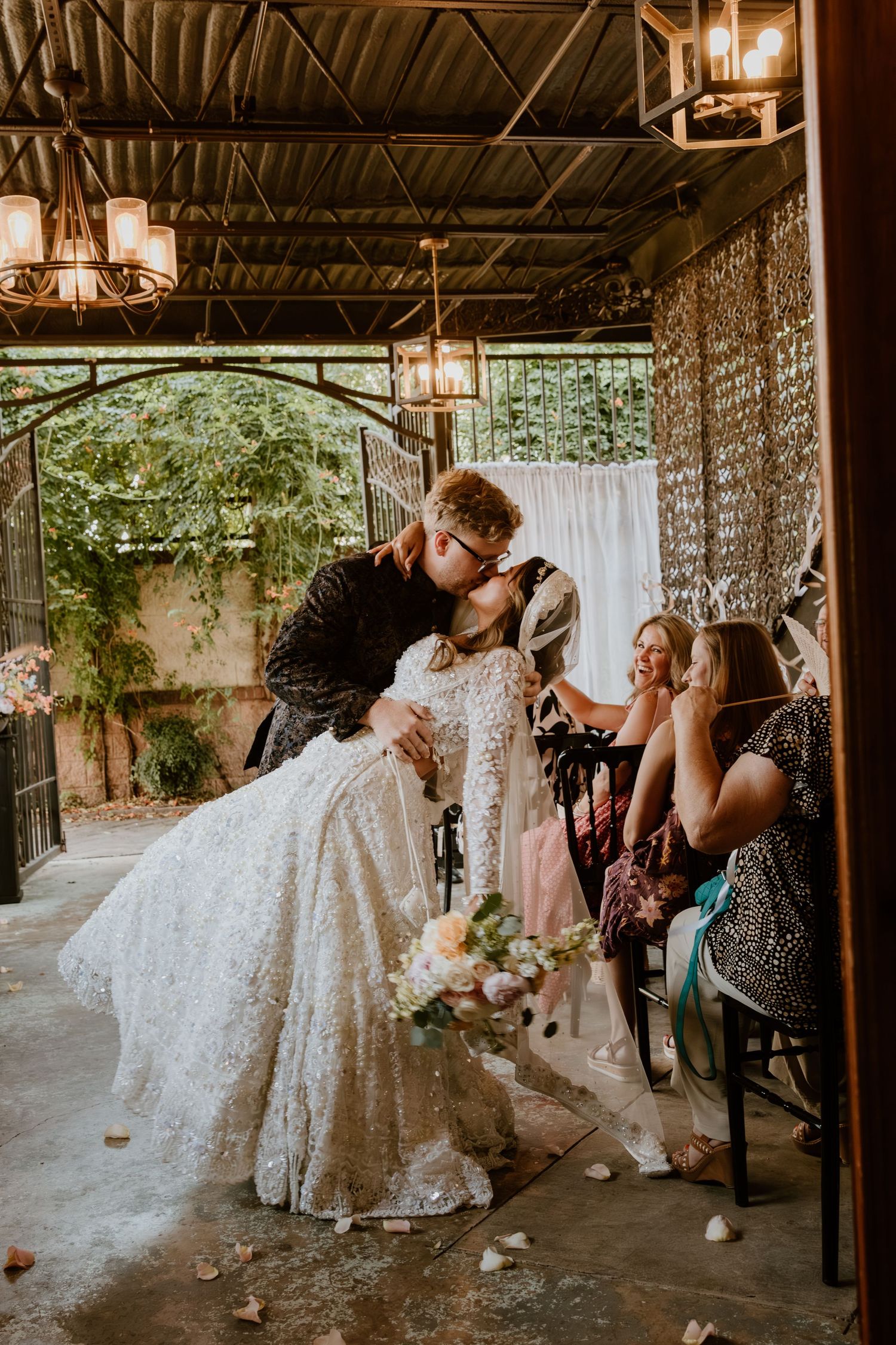 Wedding reception dance under crystal chandeliers with guests celebrating.