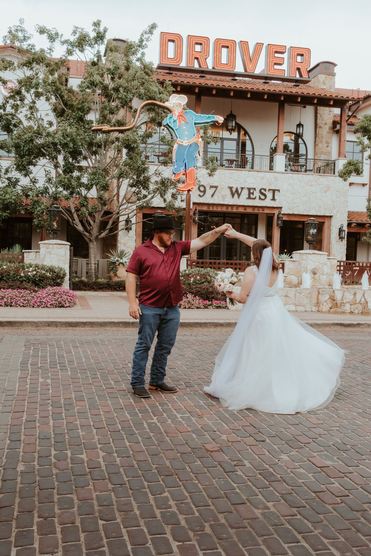 Wedding couple posing playfully in front of Denver's historic 97 West building.
