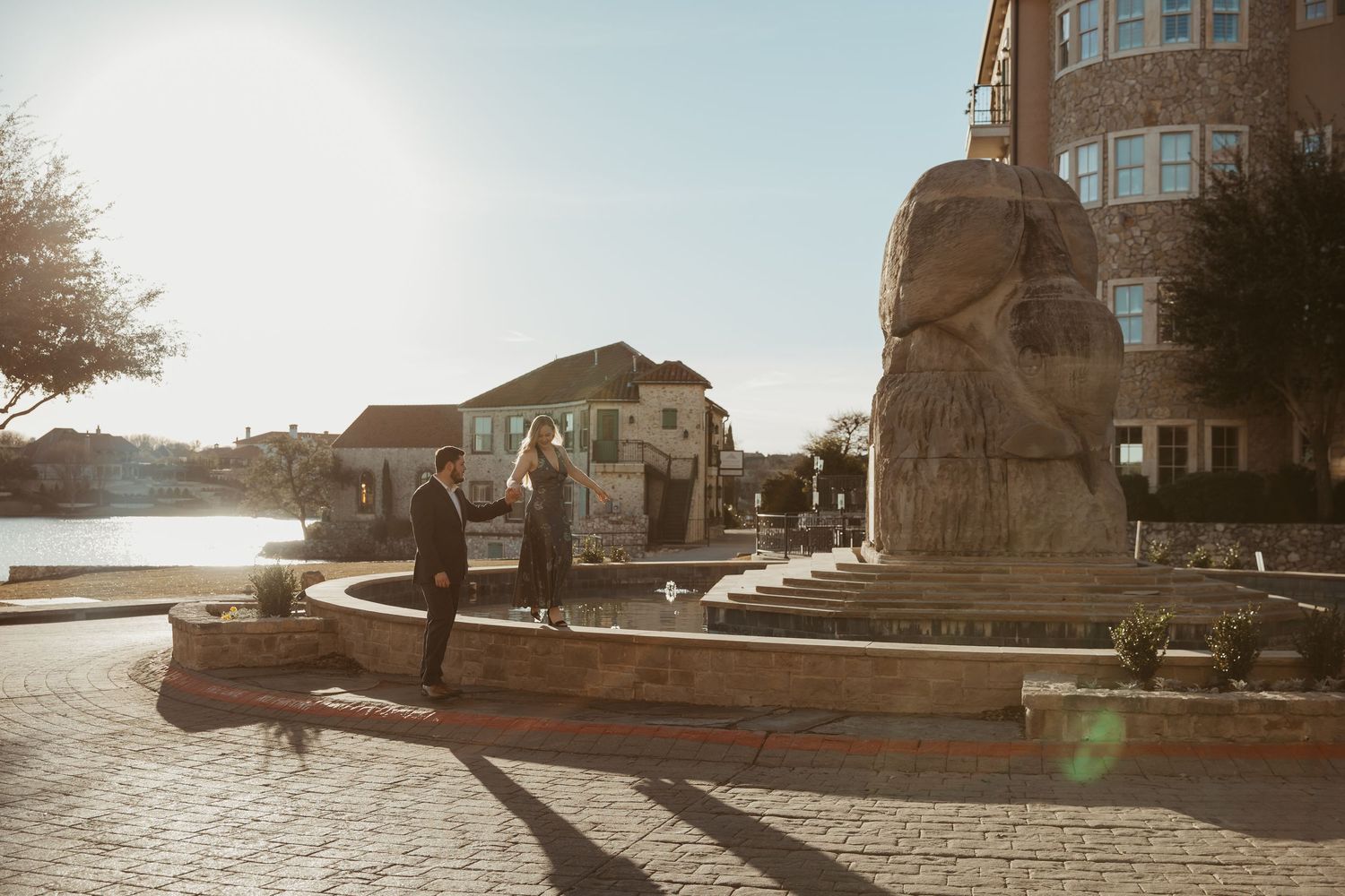 Scenic panoramic view of a historic stone building on a waterfront during sunset with warm golden lighting.