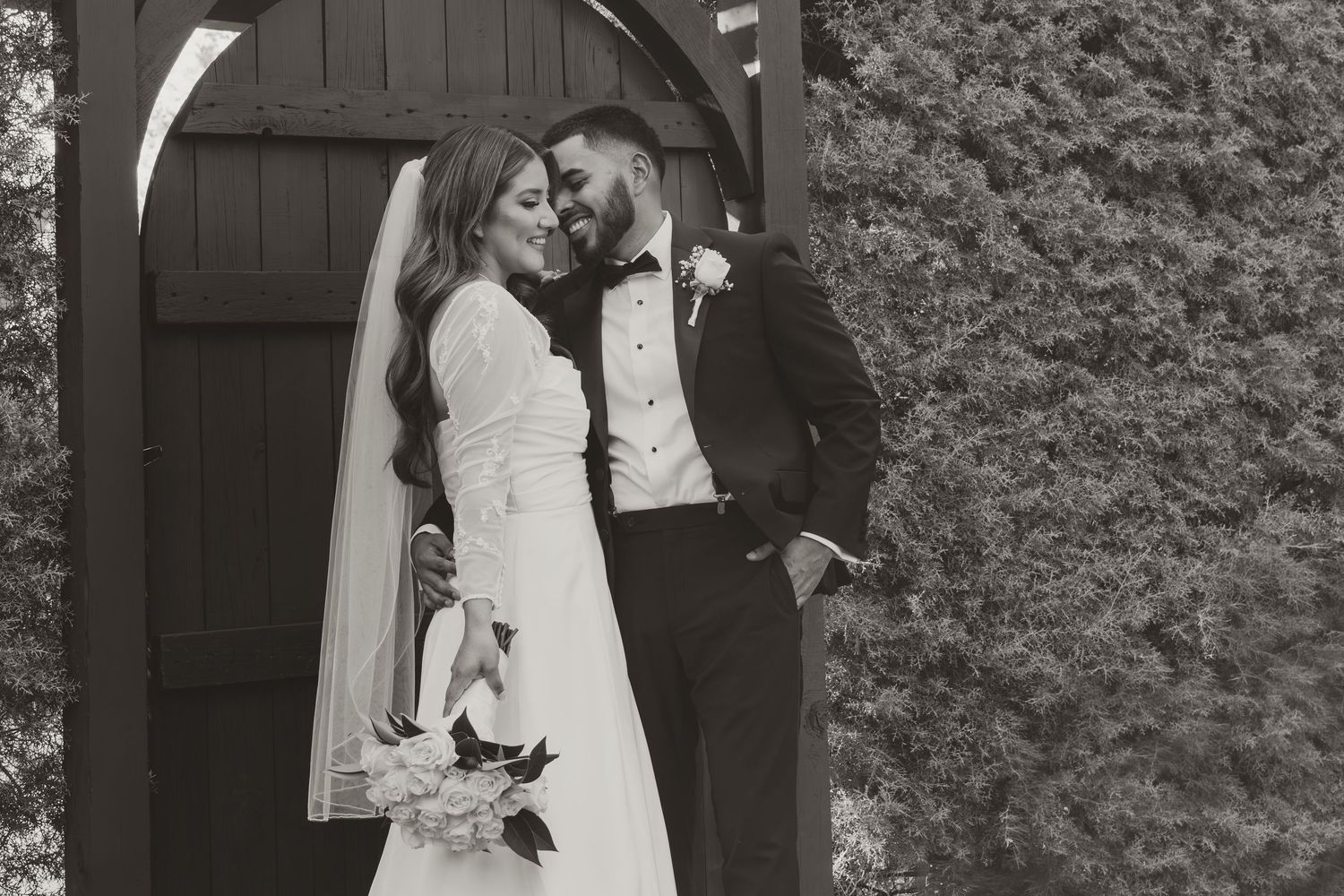 A black and white wedding photo collage showing intimate moments between a couple outside a rustic wooden door. Wedding Photographer DFW