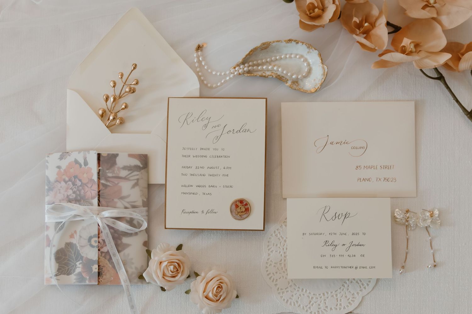 Elegant wedding invitation suite with dried flowers and delicate beige roses arranged on white background.