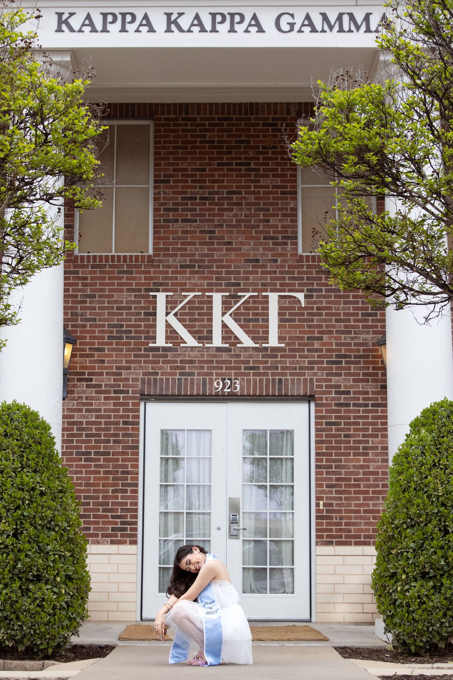 The entrance of a Kappa Kappa Gamma sorority house with Greek letters on red brick facade and white trim.