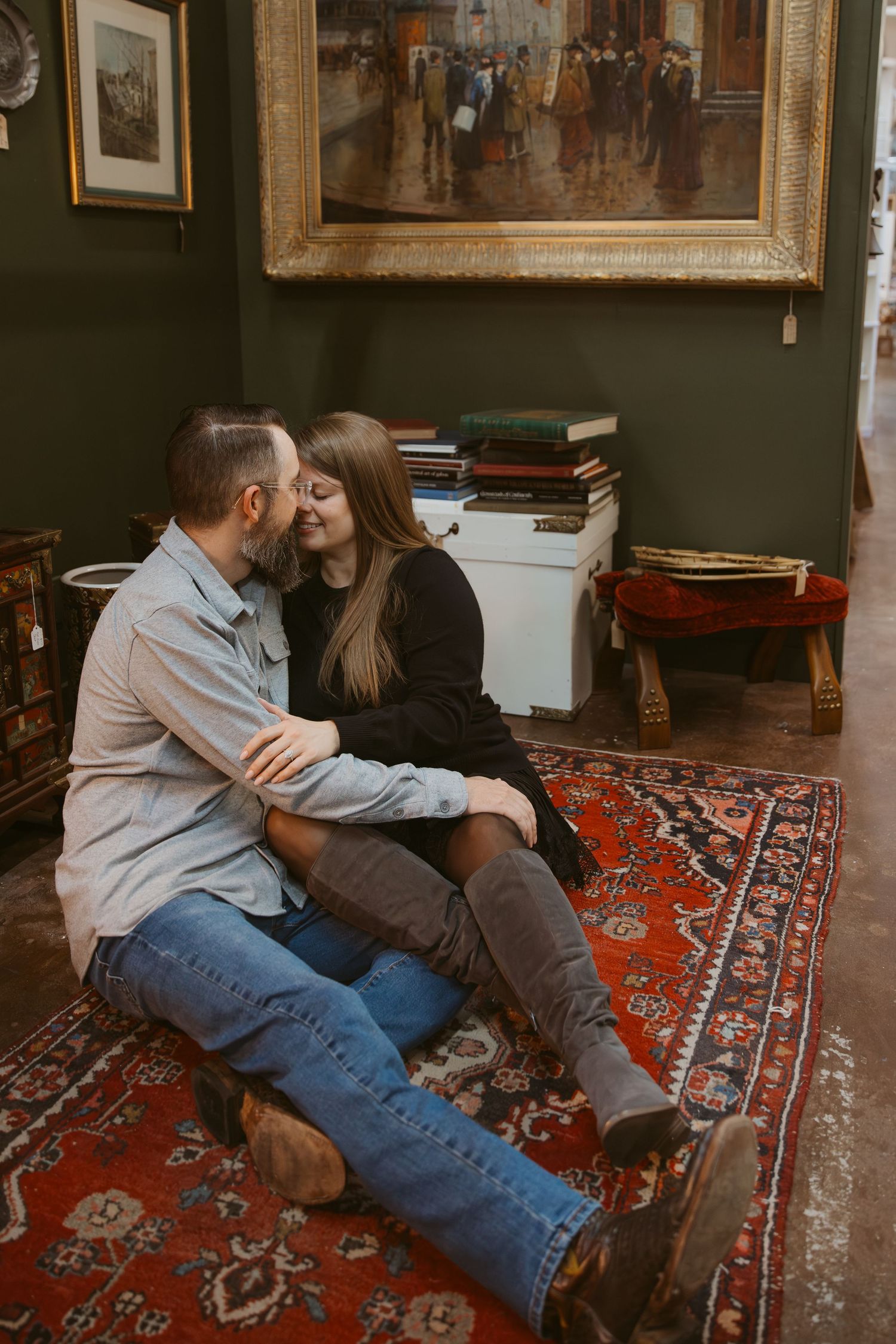 Couple sharing an intimate moment together on a vintage patterned red carpet in a cozy room.