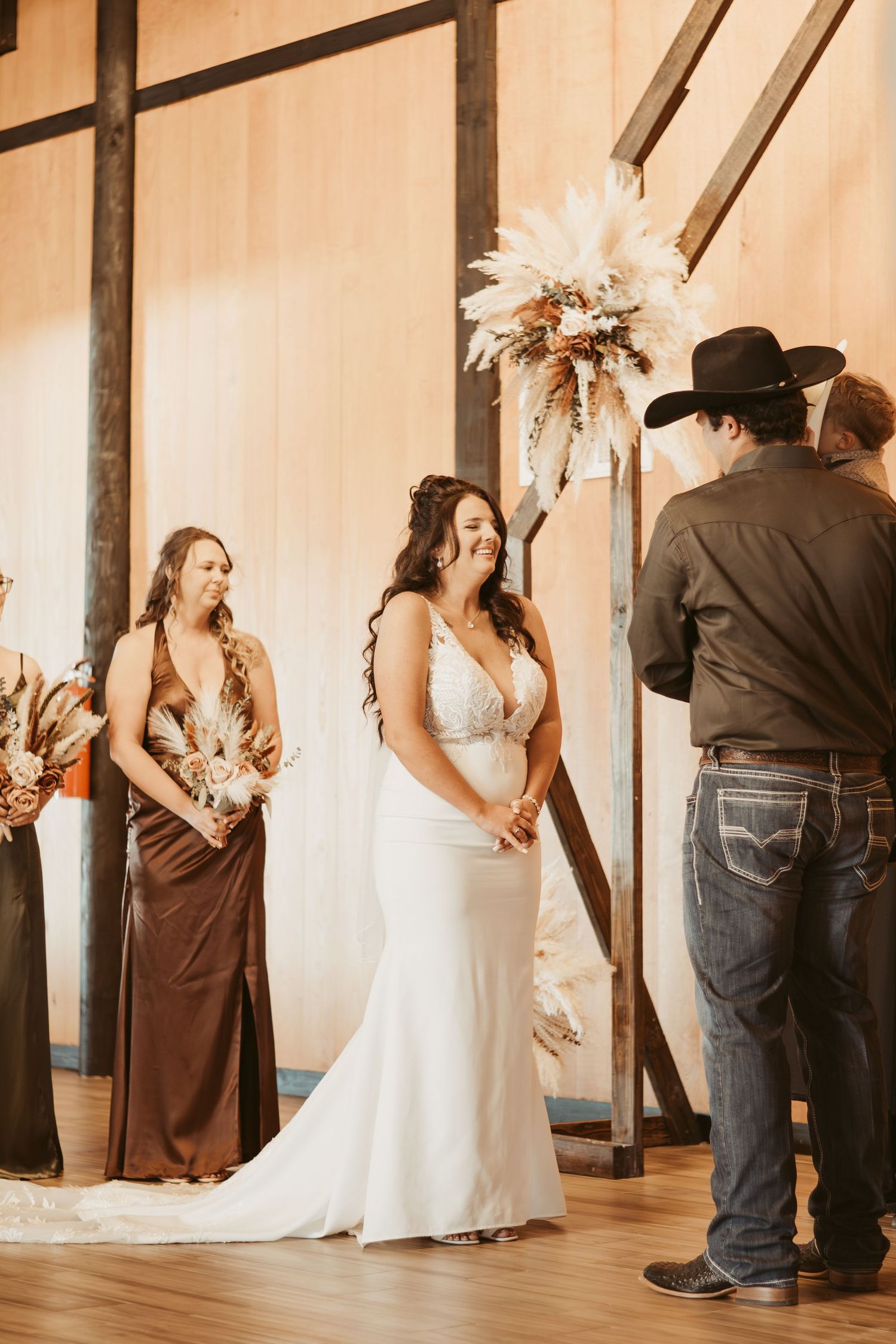 Wedding celebration in a rustic barn venue with wooden beams and warm lighting. Wedding photographer DFW
