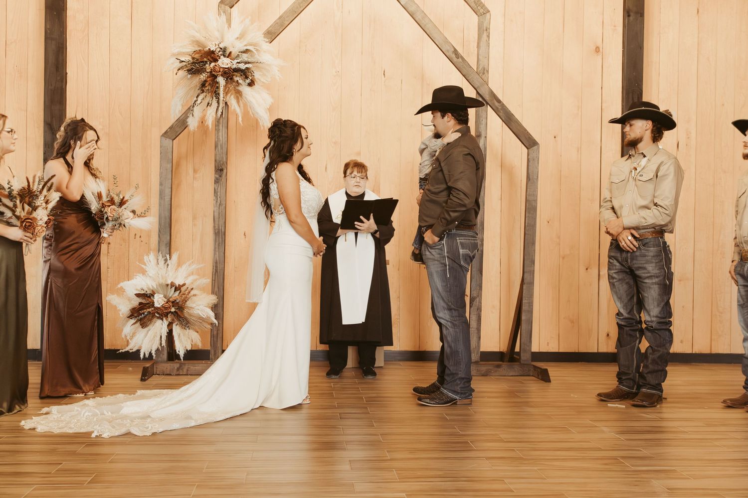 Wedding ceremony setup in a rustic barn venue with wooden walls and natural lighting. Wedding photographer DFW