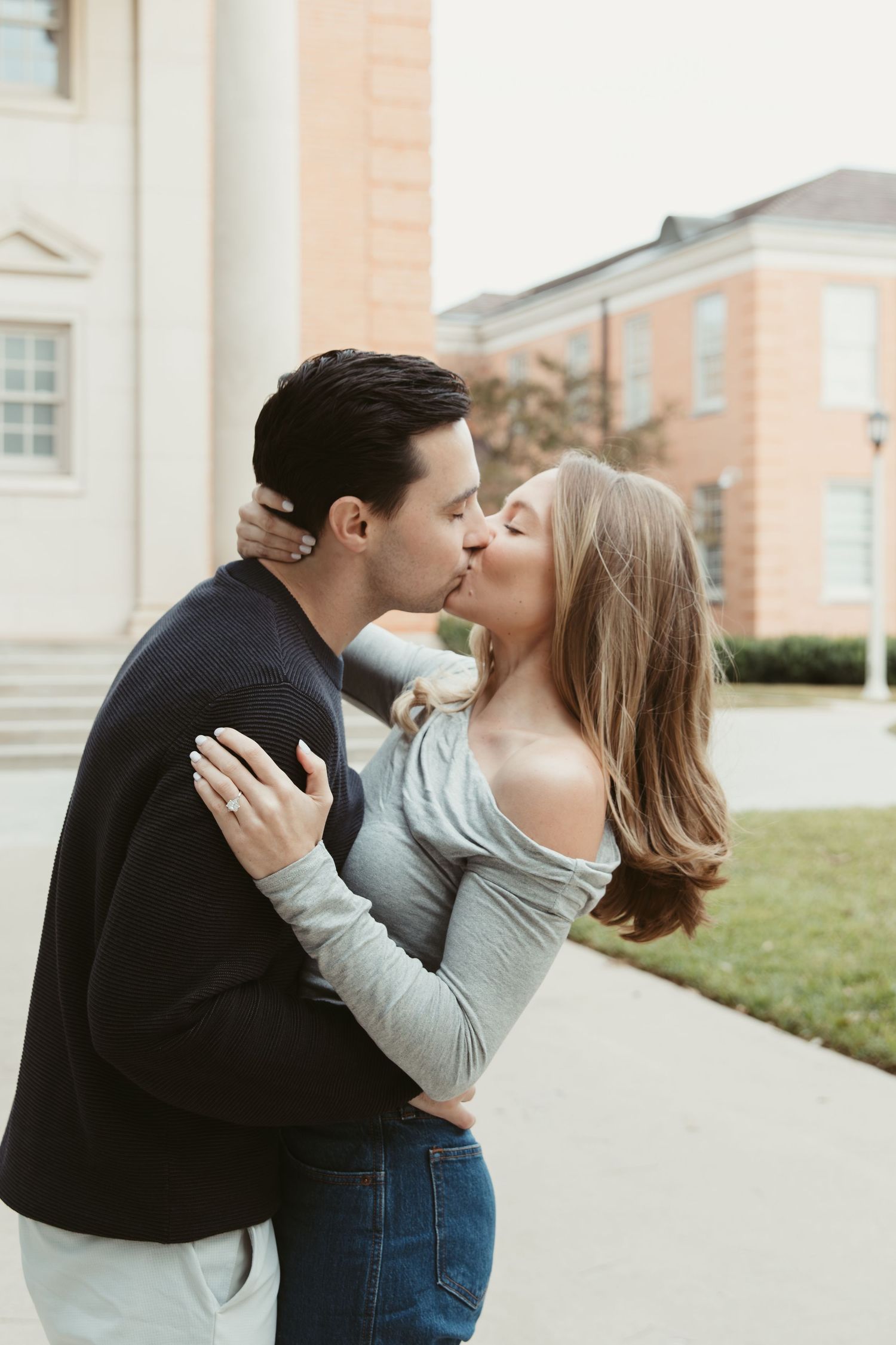 A couple shares a romantic kiss in front of a brick building, shown in a series of three connected photos.