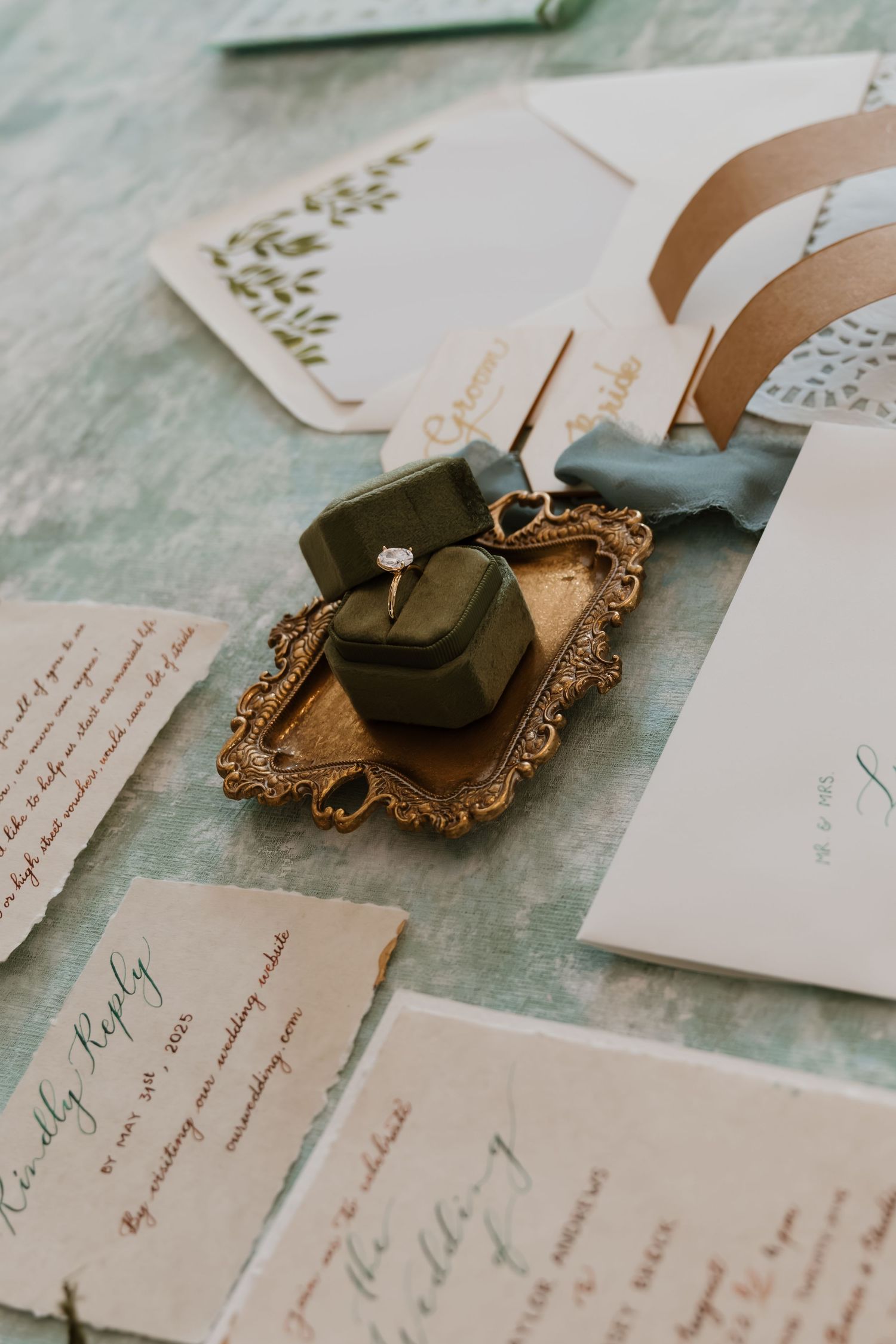 Elegant wedding invitation suite with handwritten calligraphy and vintage wax seals on a textured surface.