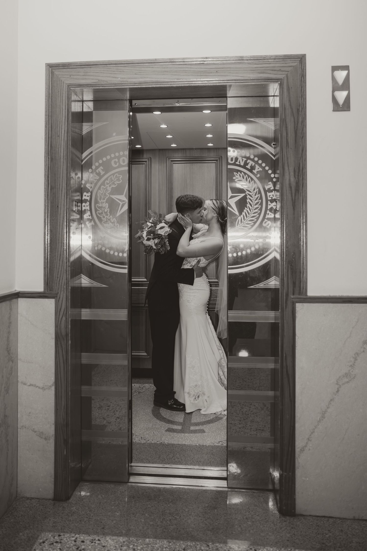 A series of four black and white photos showing a couple dancing in an elevator with etched glass doors.