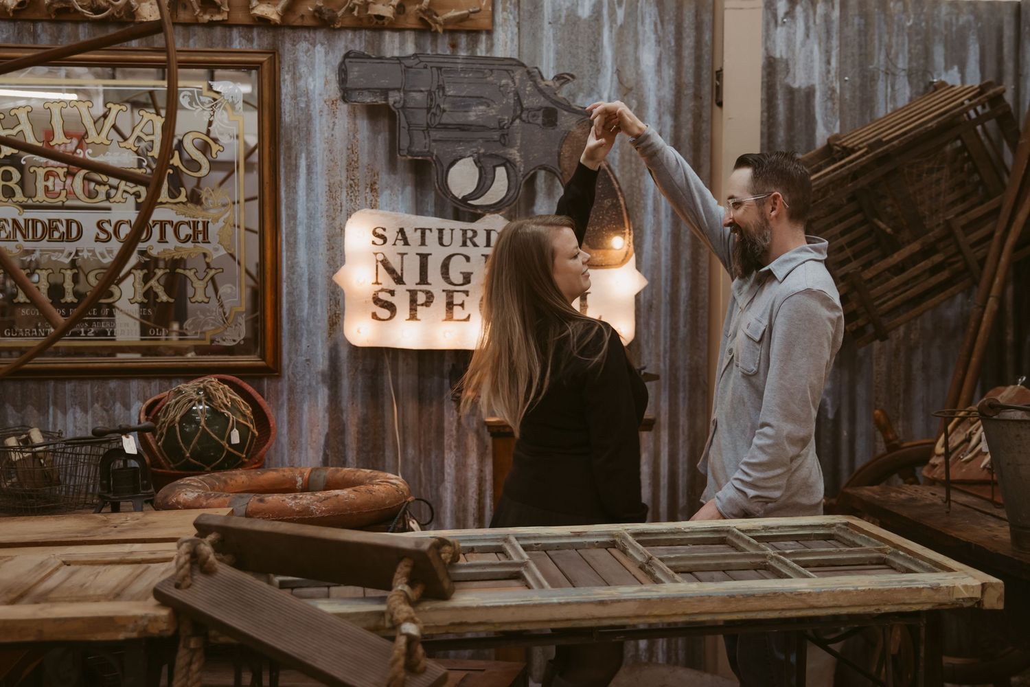 Bartender crafting cocktails at a rustic wooden bar with vintage decor and warm lighting.