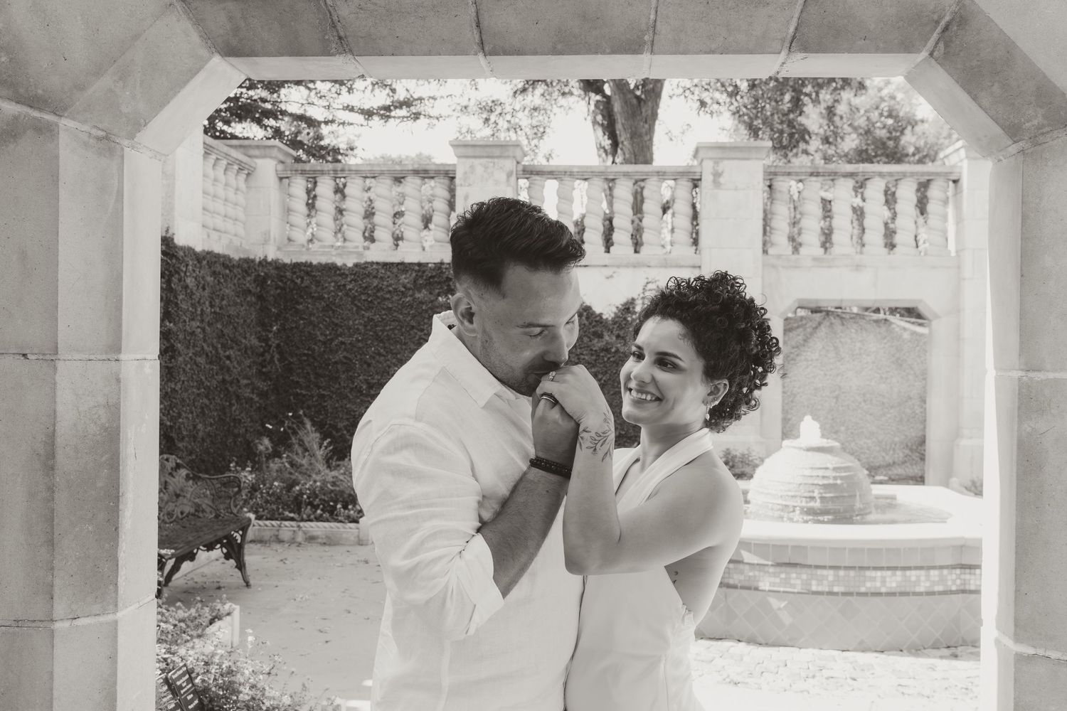 A couple shares an intimate moment while dancing together at an outdoor wedding reception.