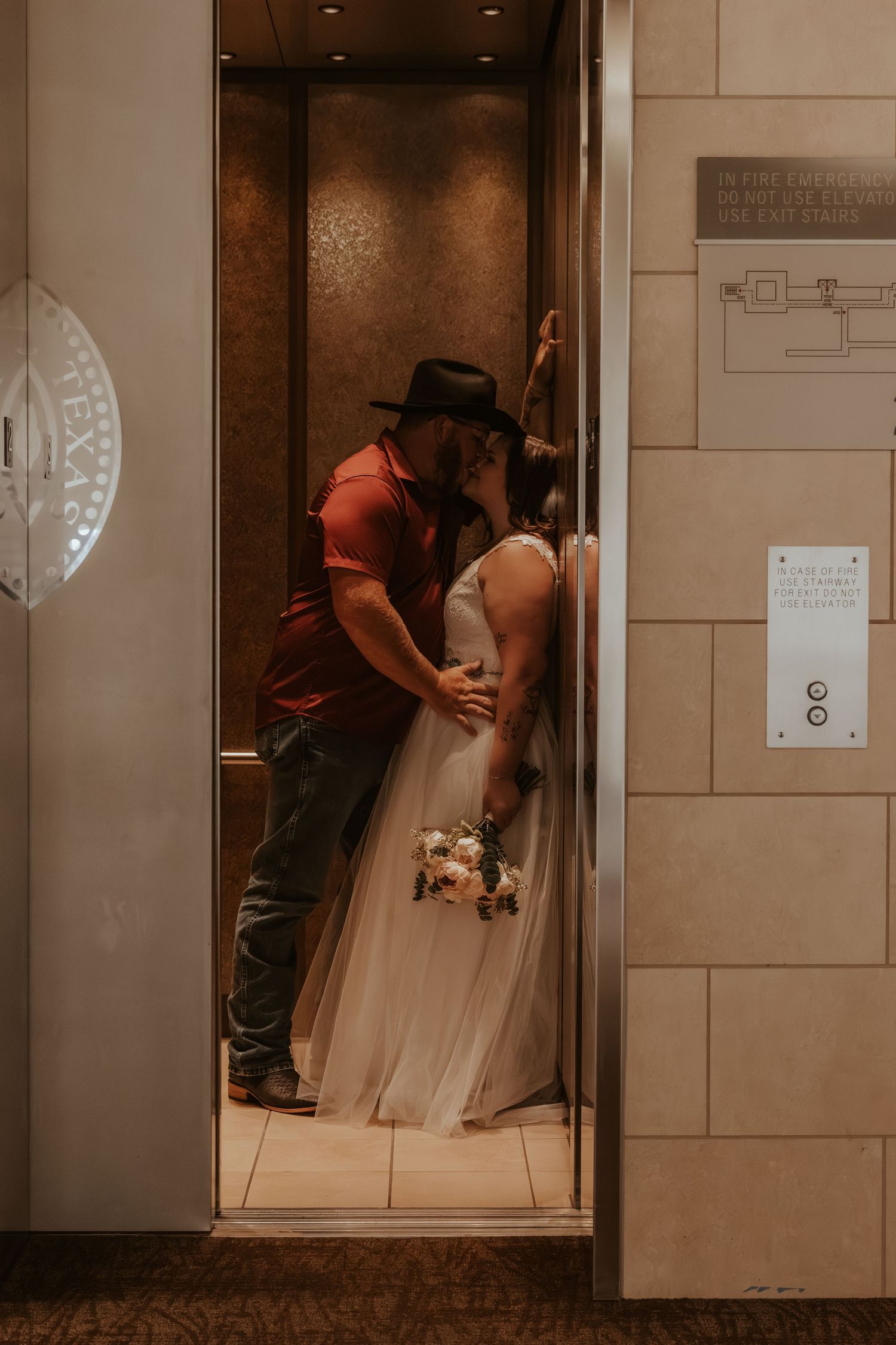 Wedding couple sharing intimate moment in elevator.