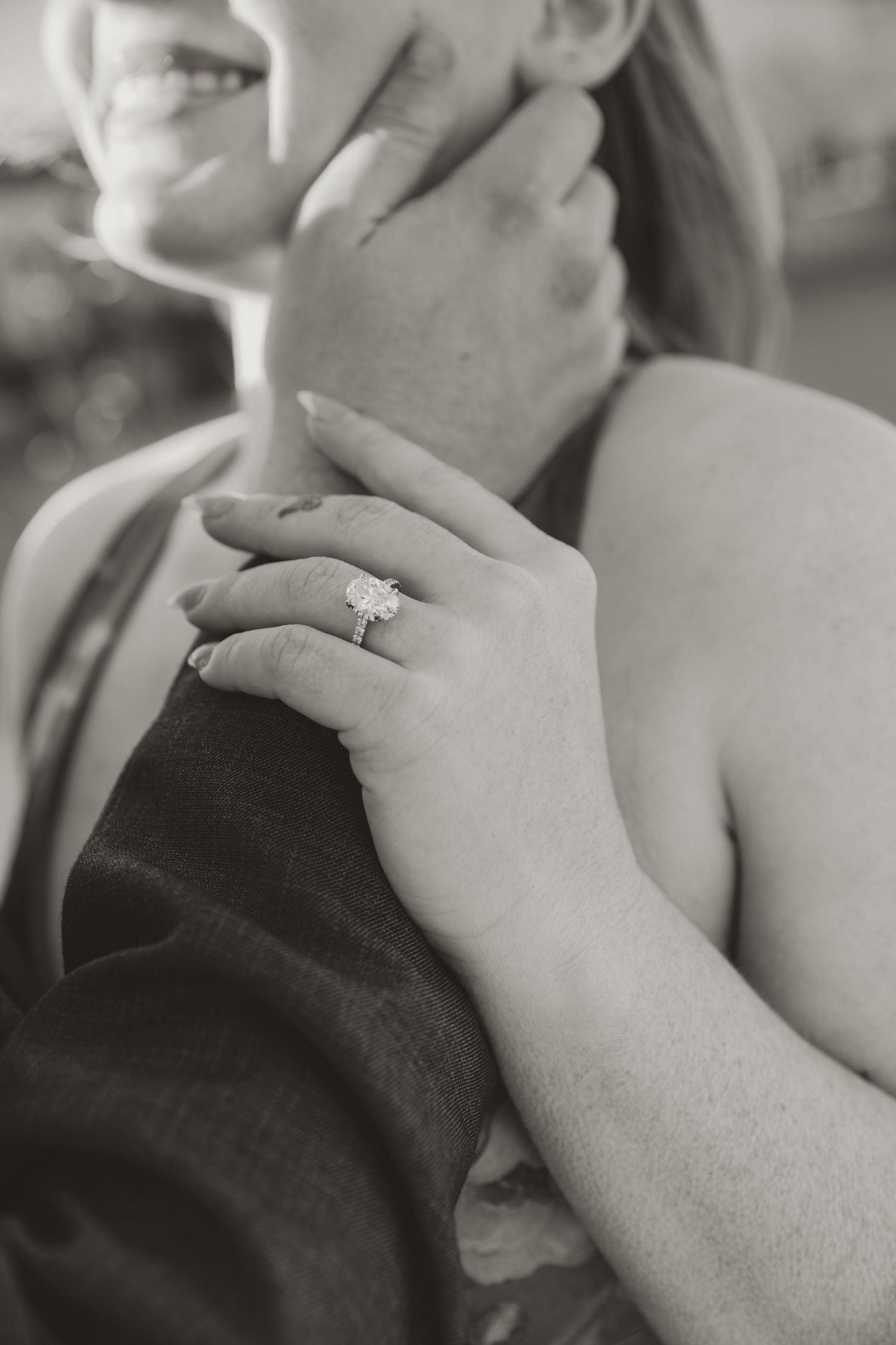 An intimate black and white photograph showing hands gently caressing during a romantic moment.