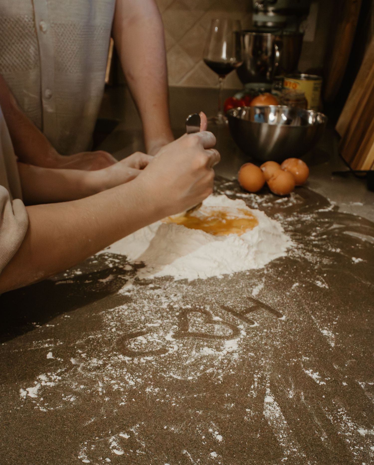 Making homemade pasta dough with eggs and flour on a floured kitchen counter.