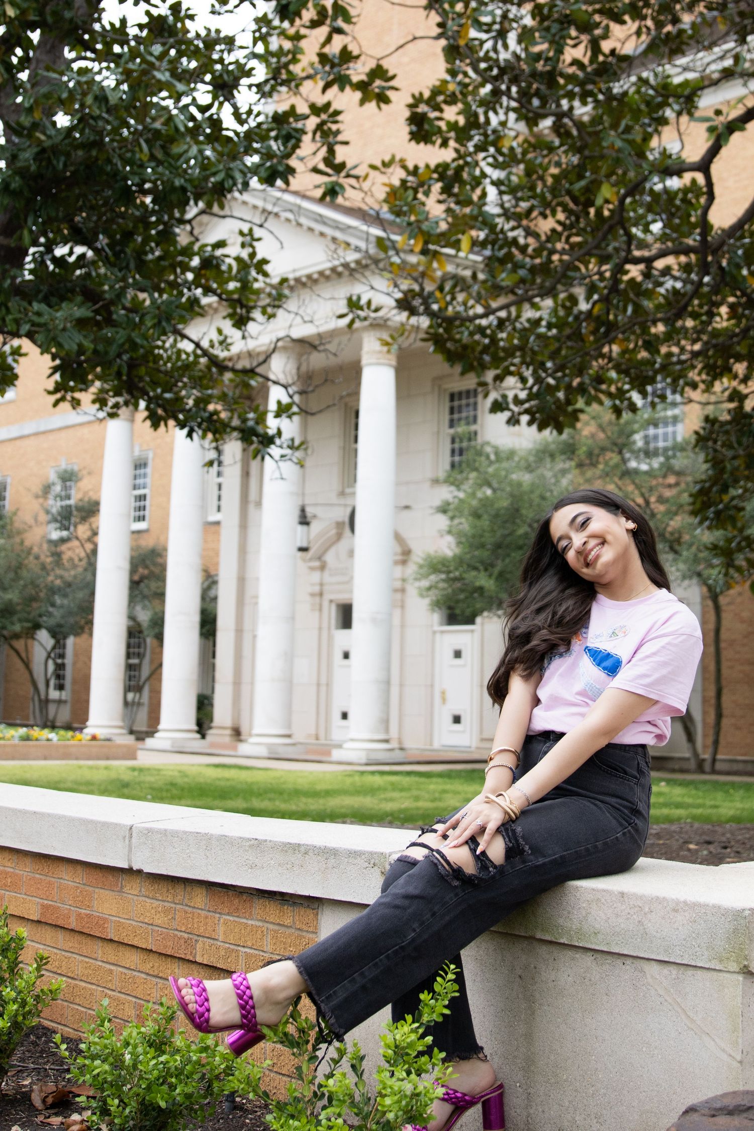 A casual portrait against a neoclassical building with white columns and brick details.