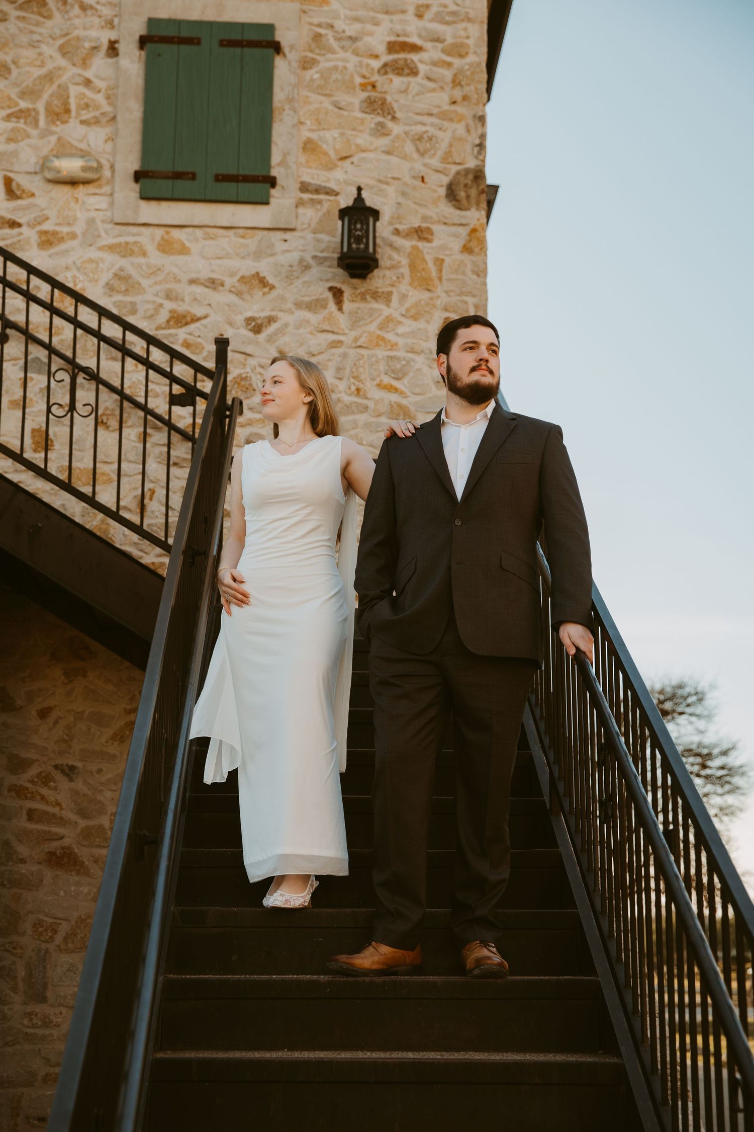Artistic wedding photo series showing couple on stone staircase with dramatic lighting and architectural backdrop.