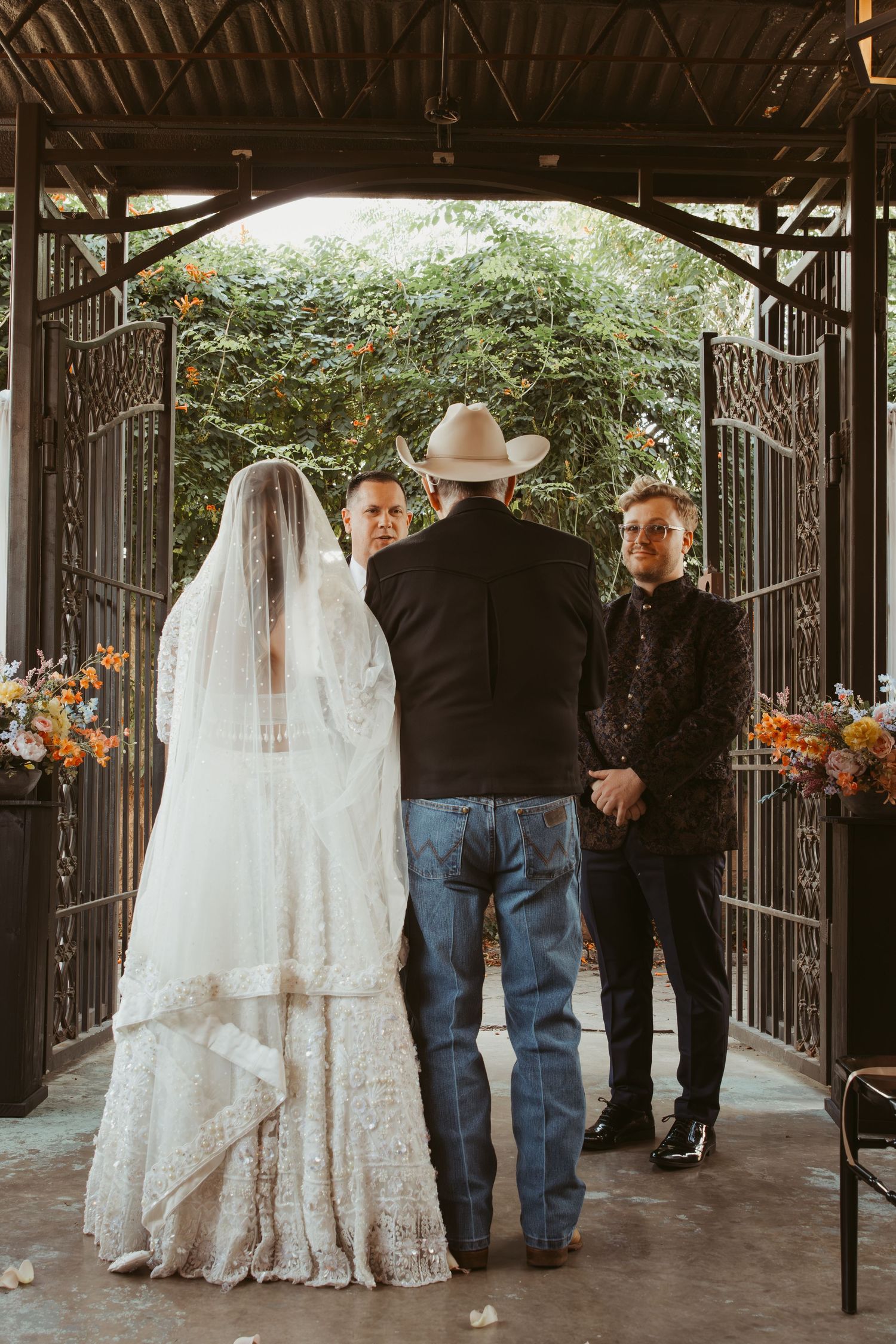 White lace wedding dress displayed in a covered outdoor venue with wrought iron details.