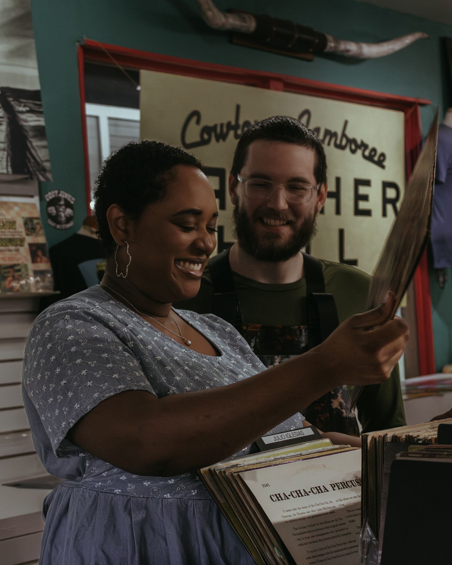 Two people looking at documents and smiling together in a casual indoor setting.