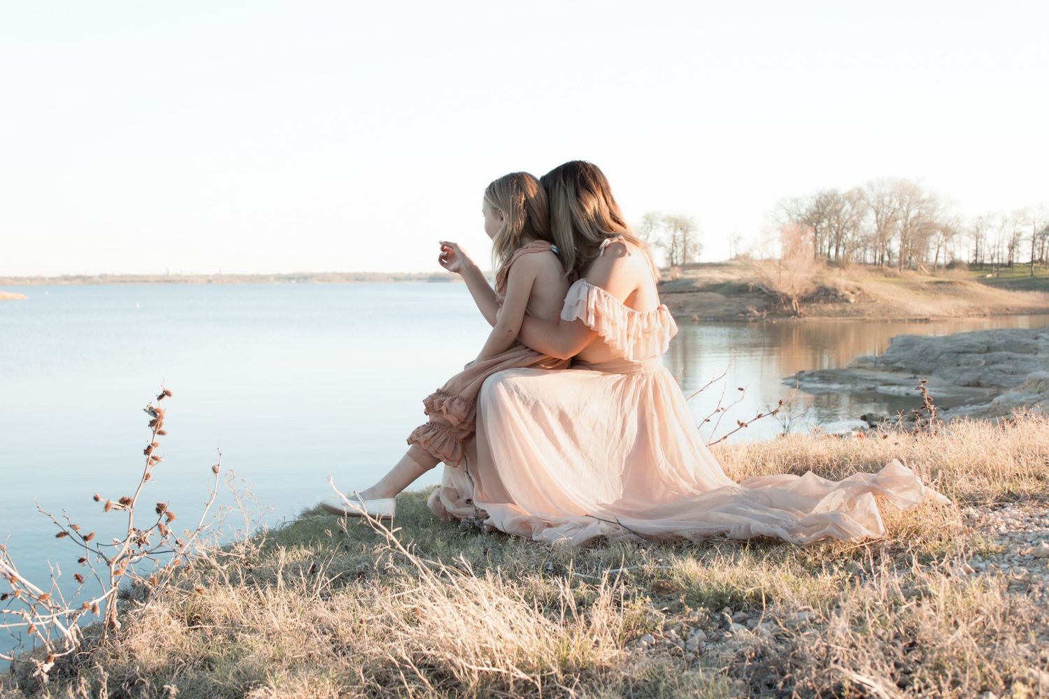 Ethereal sunset photo session in a golden field with soft pink and warm tones creating a dreamy atmosphere. Wedding photographer DFW