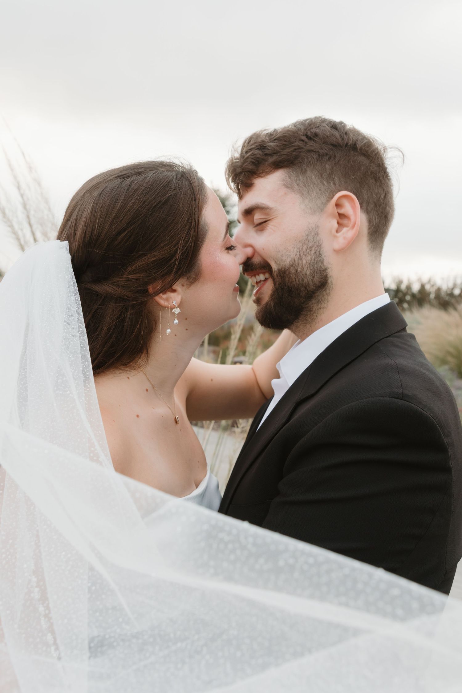 A romantic wedding portrait series shows tender moments between newlyweds against an overcast sky. Wedding Photographer Fort Worth