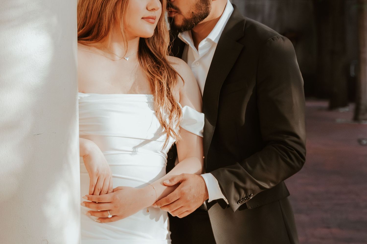 A couple in formal wedding attire embrace in an intimate moment during their special day. Engagement photographer DFW