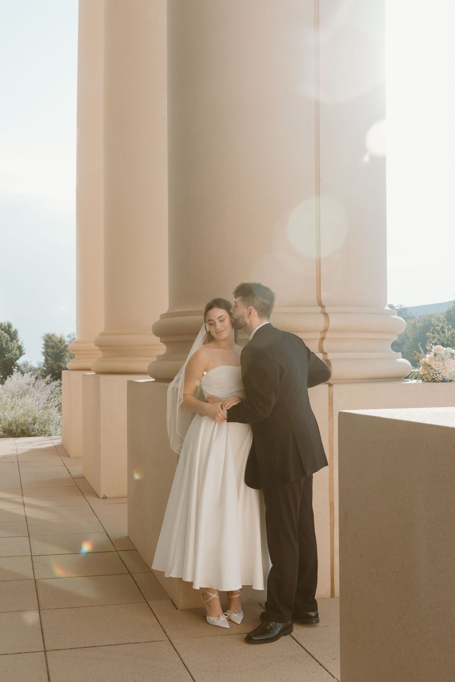 A dreamy wedding photo sequence showing tender moments between a couple against white architectural columns. Wedding Photographer Fort Worth