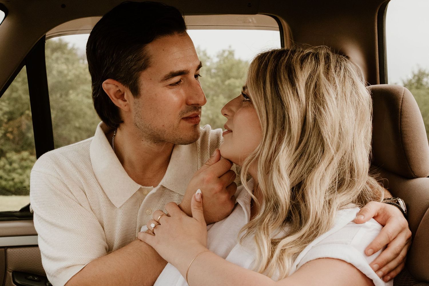 A romantic couple shares an intimate moment together inside a car.